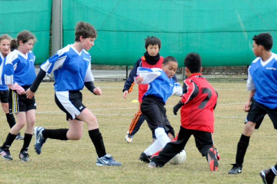 The son of U.S. Air Force Capt. Jennifer Franks, center, 35th Medical Surgical Squadron, goes in to steal the ball during a joint-youth soccer game at Sendai, Japan, April 1, 2012. The City of Sendai extended an invitation for American elementary school students from Misawa Air Base to participate in a Japan-U.S. soccer exchange before a professional match between the U.S. Major League Soccer women’s team and Japanese women’s team later that night. (U.S. Air Force photo by 2nd Lt. Son Lee/Released)