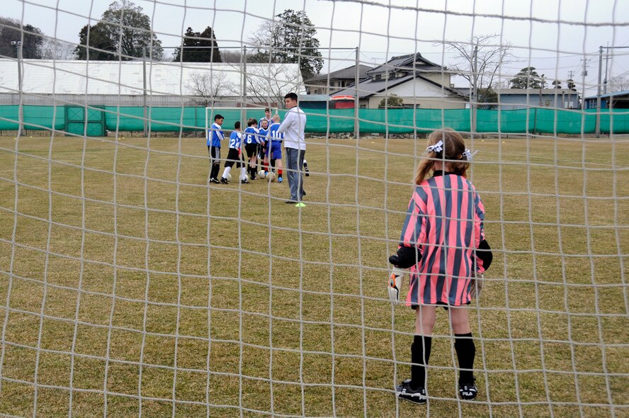 The daughter of U.S. Air Force Capt. Justin Kandle, 35th Medical Surgical Squadron, plays goalie during a warm-up activity before a joint-youth soccer game at Sendai, Japan, April 1, 2012. To celebrate the 100-year anniversary of the Japanese gift of more than 3,000 cherry trees to the United States, the city of Sendai invited 14 children from Misawa Air Base to play in a soccer match before Hope Solo and the rest of the U.S. Major League Soccer women’s team played the Japanese women’s national team later that night. (U.S. Air Force photo by 2nd Lt. Son Lee/Released)