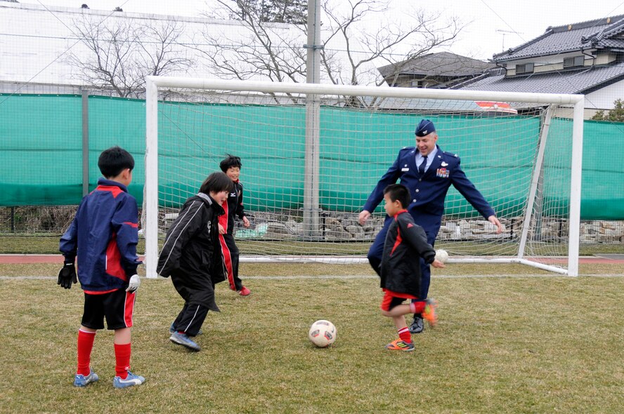 U.S. Air Force Col. Sam Shaneyfelt, 35th Operations Group commander, warms up with Japanese children before a game at Sendai, Japan, April 1, 2012. Fourteen children from Misawa Air Base were invited to play in a joint-youth soccer game against Japanese children from Sendai to commemorate the centennial of the Japanese gift of more than 3,000 cherry trees to the United States in 1912. (U.S. Air Force photo by 2nd Lt. Son Lee/Released)
