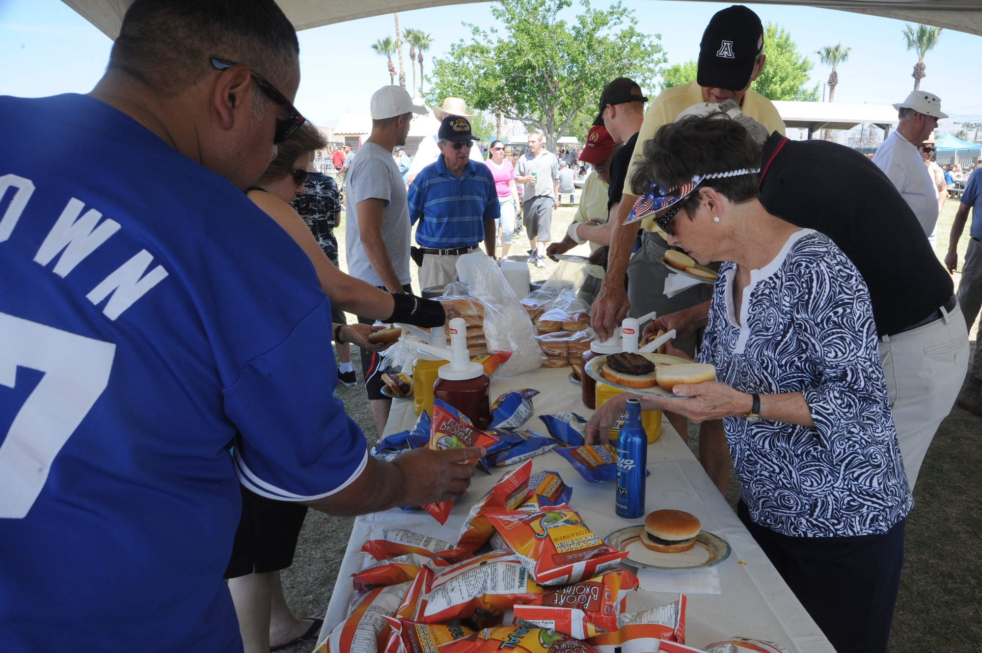 Attendees of the D-M 50 picnic prepare their plates at Davis-Monthan Air Force Base, Ariz., March 31, 2012. All D-M Airmen and their families were invited to enjoy free food and various activities, including a car show, K-9 demonstration and a petting zoo. (U.S. Air Force photo by Airman 1st Class Camilla Griffin/Released)