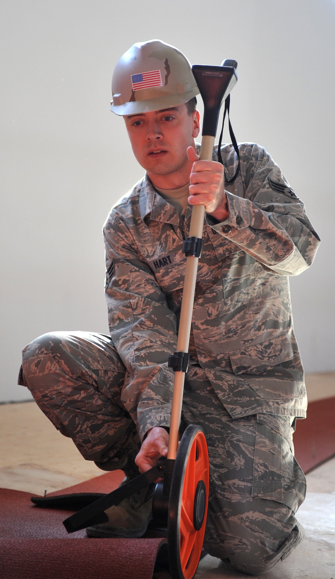U.S. Air Force Senior Airman Glenn Hart, 366th Civil Engineer Squadron engineering journeyman, measures the distance around the newly renovated indoor track April 3, 2012, at Mountain Home Air Force Base, Idaho. The many renovations are being performed by seven different companies. (U.S. Air Force photo/Airman 1st Class Heather Hayward)