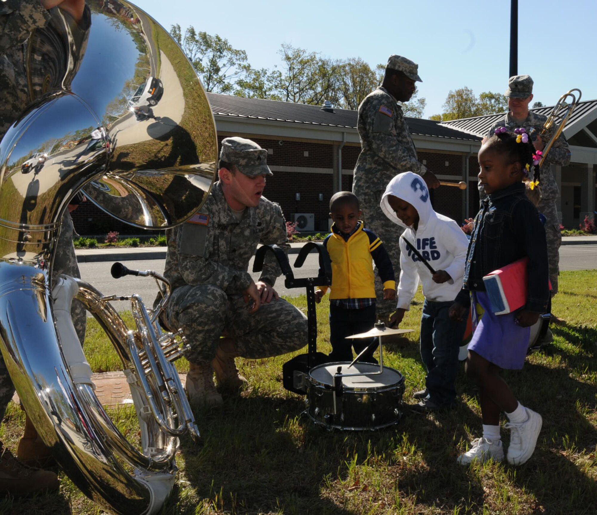 The Army Training and Doctrine Command Band share their instruments with the children from the Fort Eustis Pershing Child Development Center, April 2, 2012. The TRADOC Band came out to show their support for National Child Abuse Prevention Month. (U.S. Air Force photo by Tetaun Moffett/ Released)