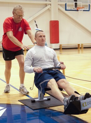 F. E. WARREN AIR FORCE BASE, Wyo. - Sean Colgan, former U.S. Olympic rower, helps correct the rowing form of Tech. Sgt. Shaun Menard, 90th Civil Engineer Squadron heavy equipment specialist, in preparation for the Air Force Global Strike Command American300 Rowing Challenge in the Freedom Hall Fitness Center March 30. (U.S. Air Force photo by Airman Jason Wiese) 