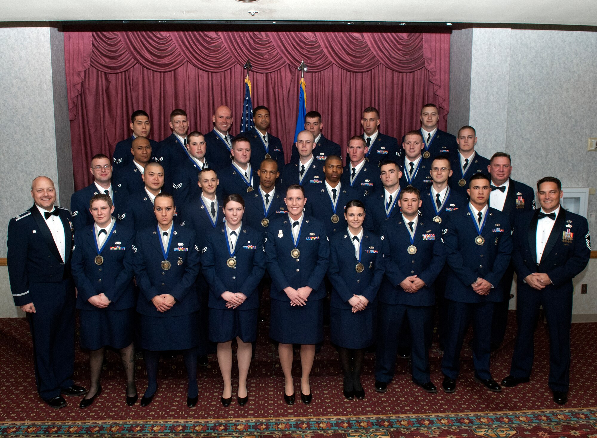Col. Christopher Coffelt, 90th Missile Wing commander, and Senior Master Sgt. Benjamin Del Mar, 790th Missile Security Forces Squadron, join Airman Leadership School Class 12-D for a photo prior to their graduation ceremony in the Trail’s End Club, March 29. (U.S. Air Force photo by R.J. Oriez)