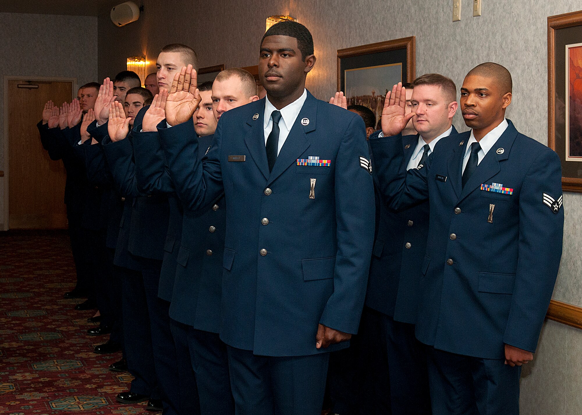 Senior Airman Joel Moses, 90th Missile Maintenance Squadron, and 24 other inductees, take the oath of induction during the 90th Missile Wing’s NCO induction ceremony March 27 in the Trail's End Club. (U.S. Air Force photo by R.J. Oriez)