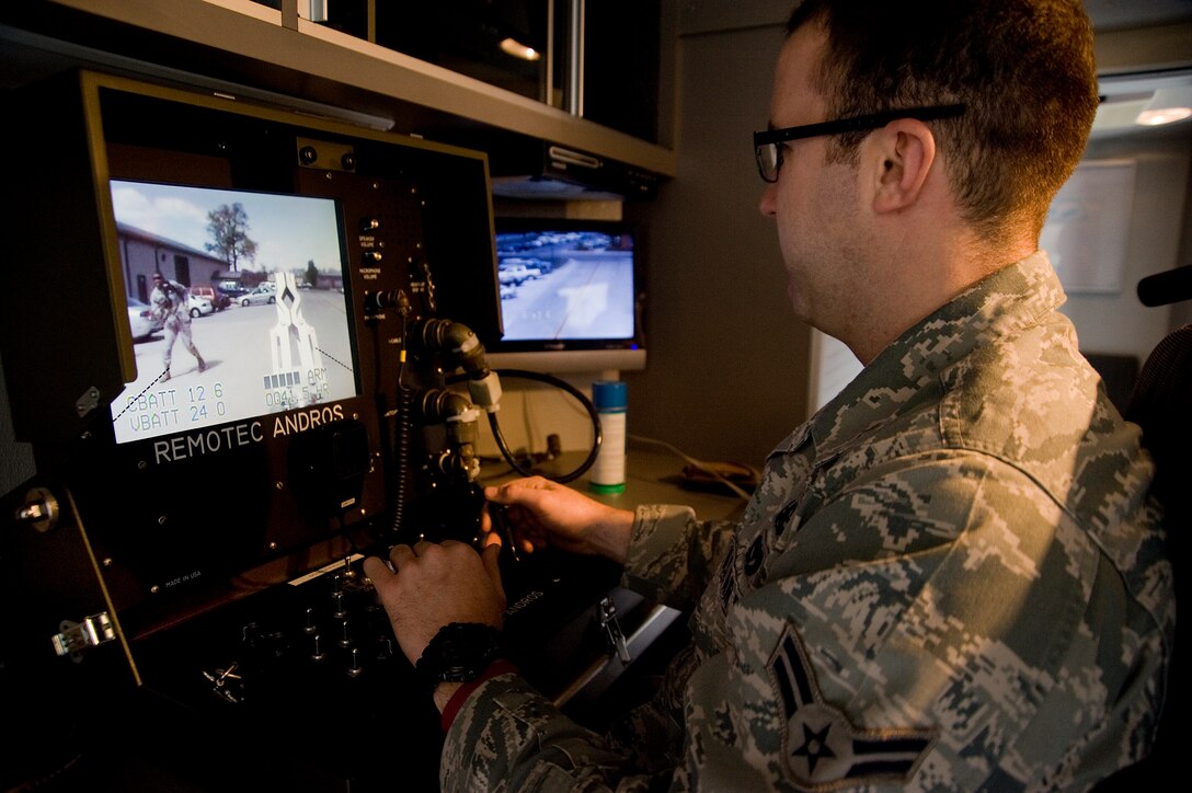 Airman 1st Class Brian Barry, 11th Civil Engineer Squadron Explosive Ordnance Disposal technician, uses a portable control unit to control an F-6A Robot during Improvised Explosive Device training near the EOD building here March 29.  (Photo/Bobby Jones)