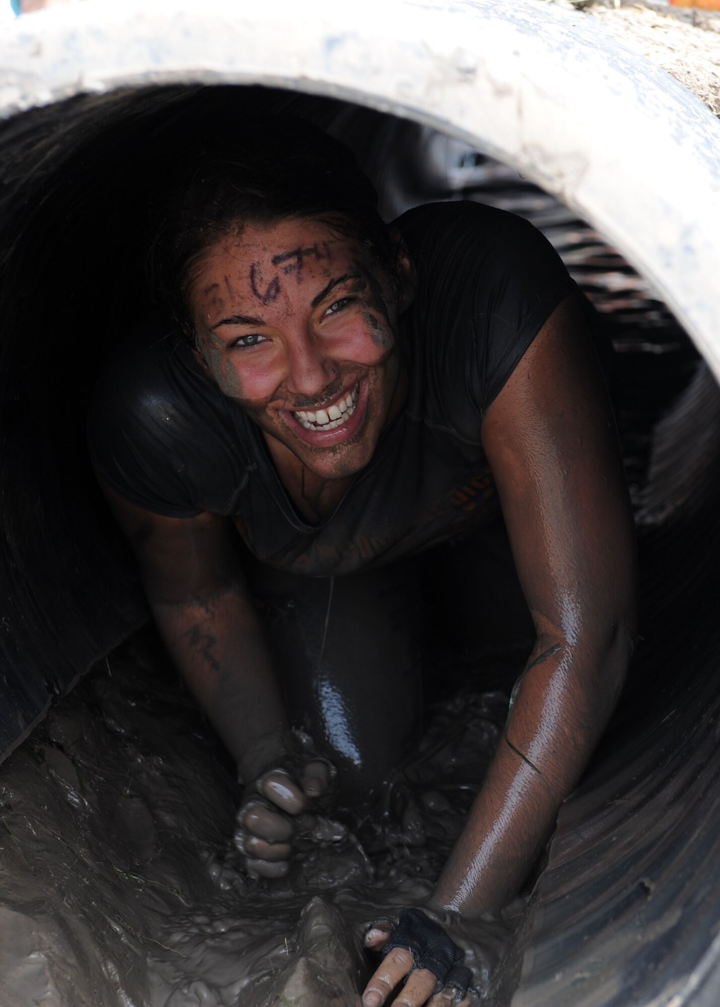 Senior Airman Cassandra Diyer, 7th Medical Operations Squadron, crawls out of an obstacle at the Dallas Tough Mudder event March 31, 2012 in Wortham, Texas. Tough Mudder events are 10-12 mile runs with obstacles designed by British Special Forces to test all around strength, stamina, mental grit and camaraderie. To date, Tough Mudder has raised more than $2,886,000 for the Wounded Warrior Project to aid and assist wounded service members. For more information on locations and events visit http://www.toughmudder.com (U.S. Air Force photo by Airman 1st Class Peter Thompson/Released)