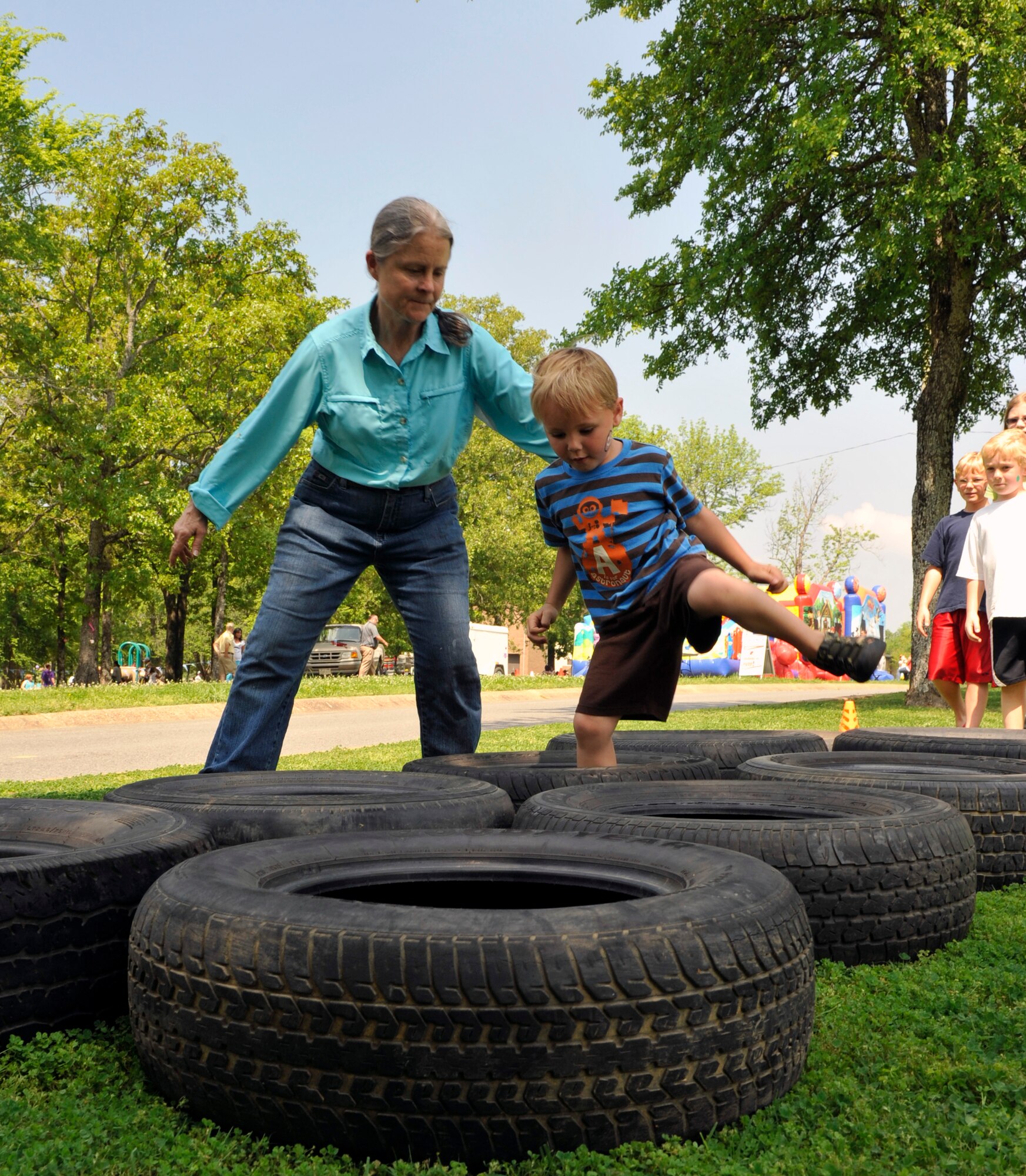 Pam Macleod, a volunteer for Family Fest, helps a child through the obstacle course, March 31, 2012, at Little Rock Air Force Base, Ark. Macleod was one of more than 100 volunteers that helped out during Family Fest. (U.S. Air Force photo by Airman 1st Class Rusty Frank)