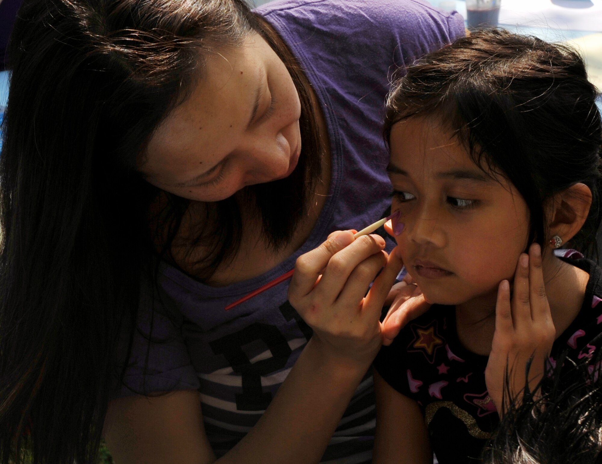A volunteer paints a child's face during Family fest, March 31, 2012, at Little Rock Air Force Base, Ark. Face painting was one many activities that children participated in during Family Fest. (U.S. Air Force photo by Airman 1st Class Rusty Frank)