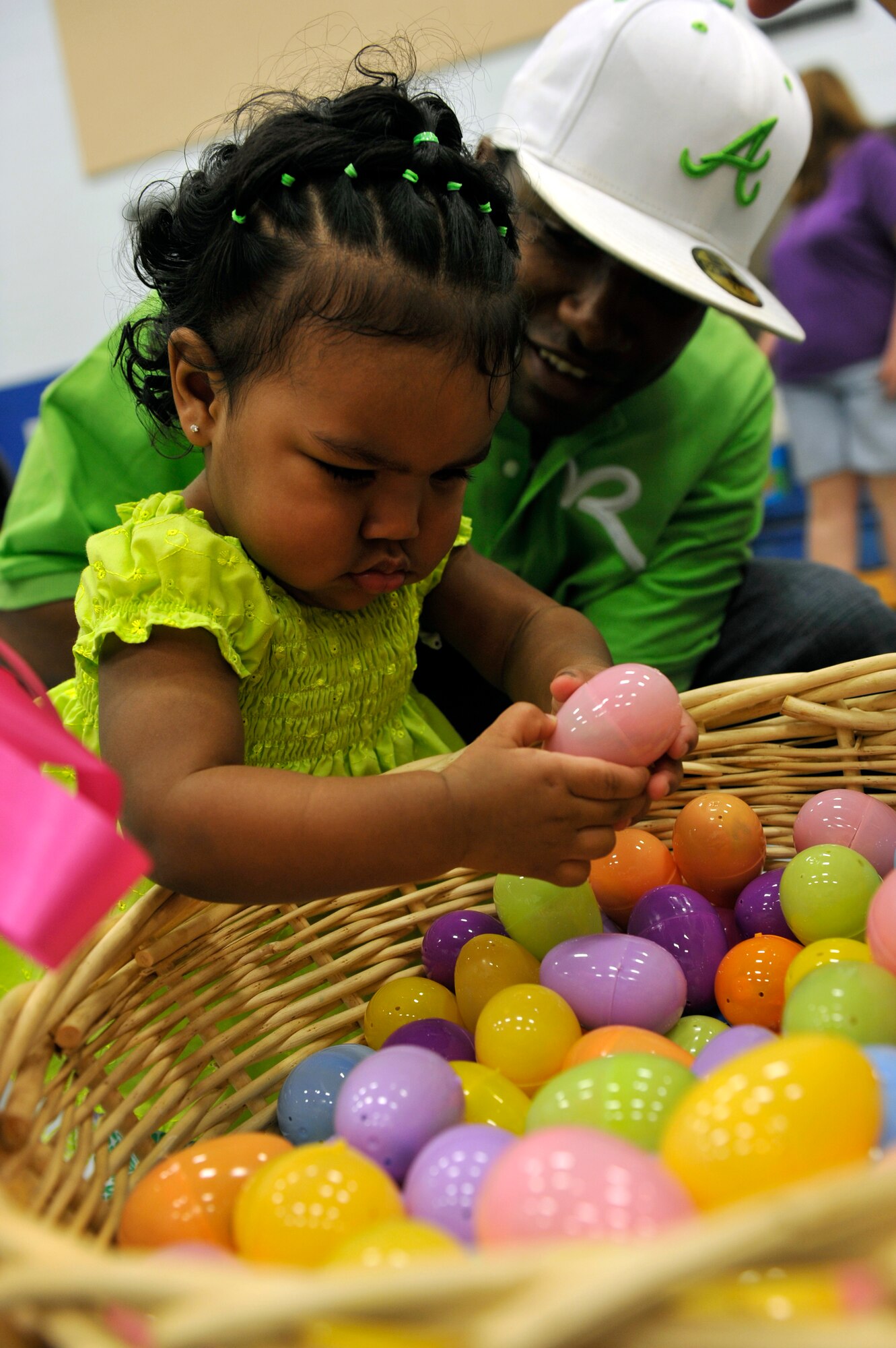 Reina Gilmore, daughter of Staff Sgt. Donald Gilmore, a 19th Security Forces patrolman, picks an Easter egg from a basket during Family Fest, March 31, 2012, at Little Rock Air Force Base, Ark.  Family Fest was held to celebrate the month of military child. This year's theme was Easter. (U.S. Air Force photo by Airman 1st Class Rusty Frank)