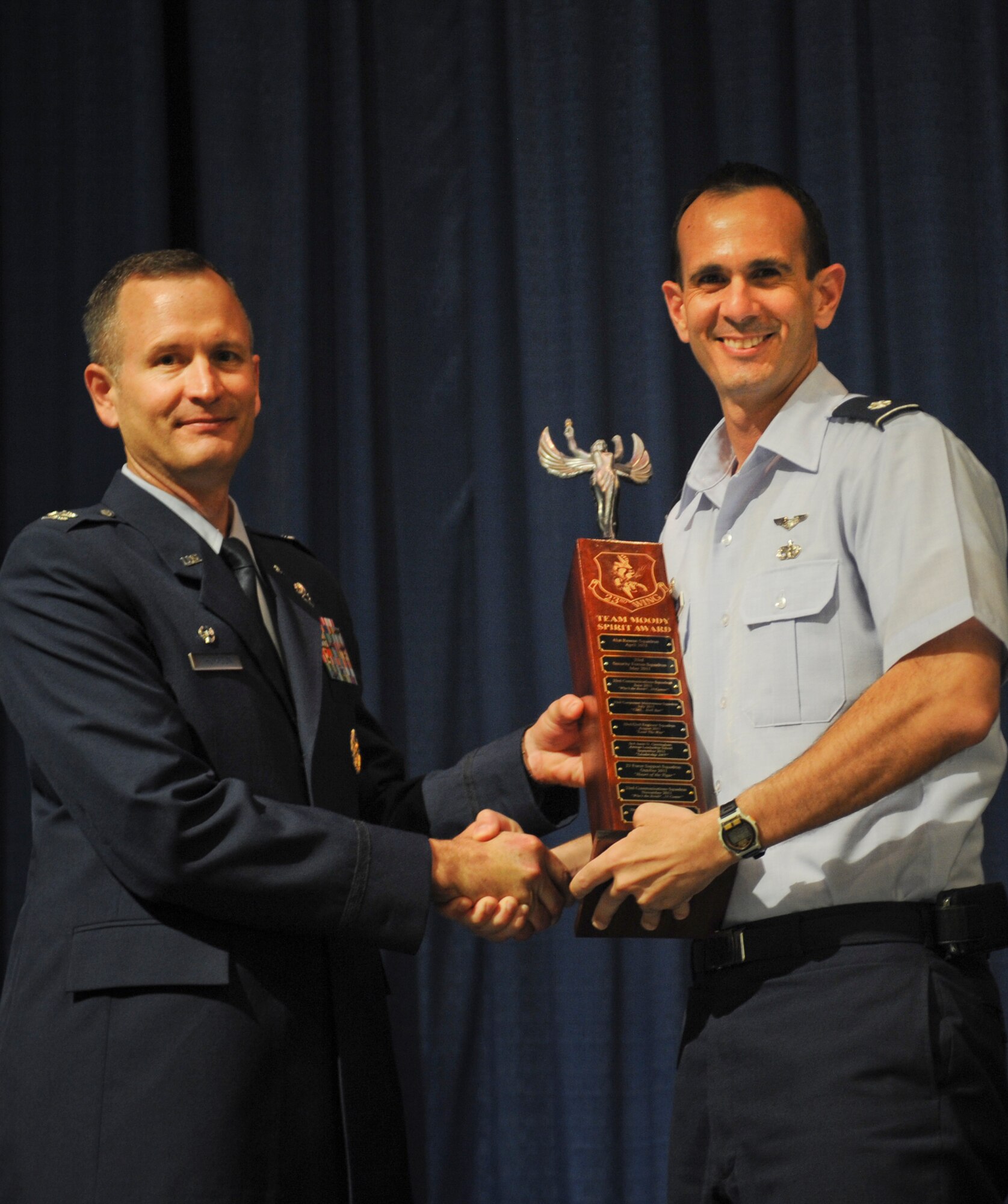U.S. Air Force Col. Billy Thompson, 23d Wing commander, presents the Moody Spirit Award to Lt. Col. Joseph Rodriguez, 23d Logistic Readiness Squadron commander, at Moody Air Force Base, Ga., April 2, 2012. 23d LRS earned the award by showing the most spirit in support of their promotees during Team Moody’s promotion ceremony. (U.S.  Air Force photo by Airman 1st Class Doug Ellis/Released)