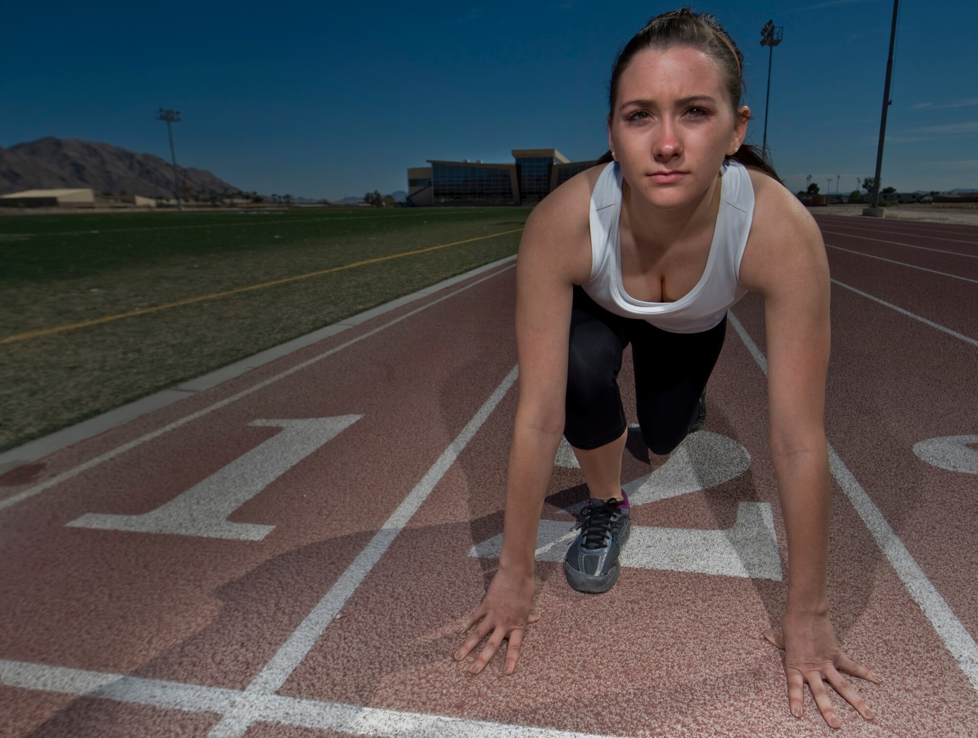 U.S. Air Force Airman 1st Class Laura Hilborne, 99th Force Support Squadron force management personnel specialist apprentice, prepares to run on the quarter mile track outside the Warrior Fitness Center April 2, 2012, at Nellis Air Force Base, Nev. In addition to the outdoor track, the new fitness center features an indoor track, an Olympic size pool, as well as cardio and weight training equipment. (U.S. Air Force photo by Airman 1st Class Daniel Hughes)
