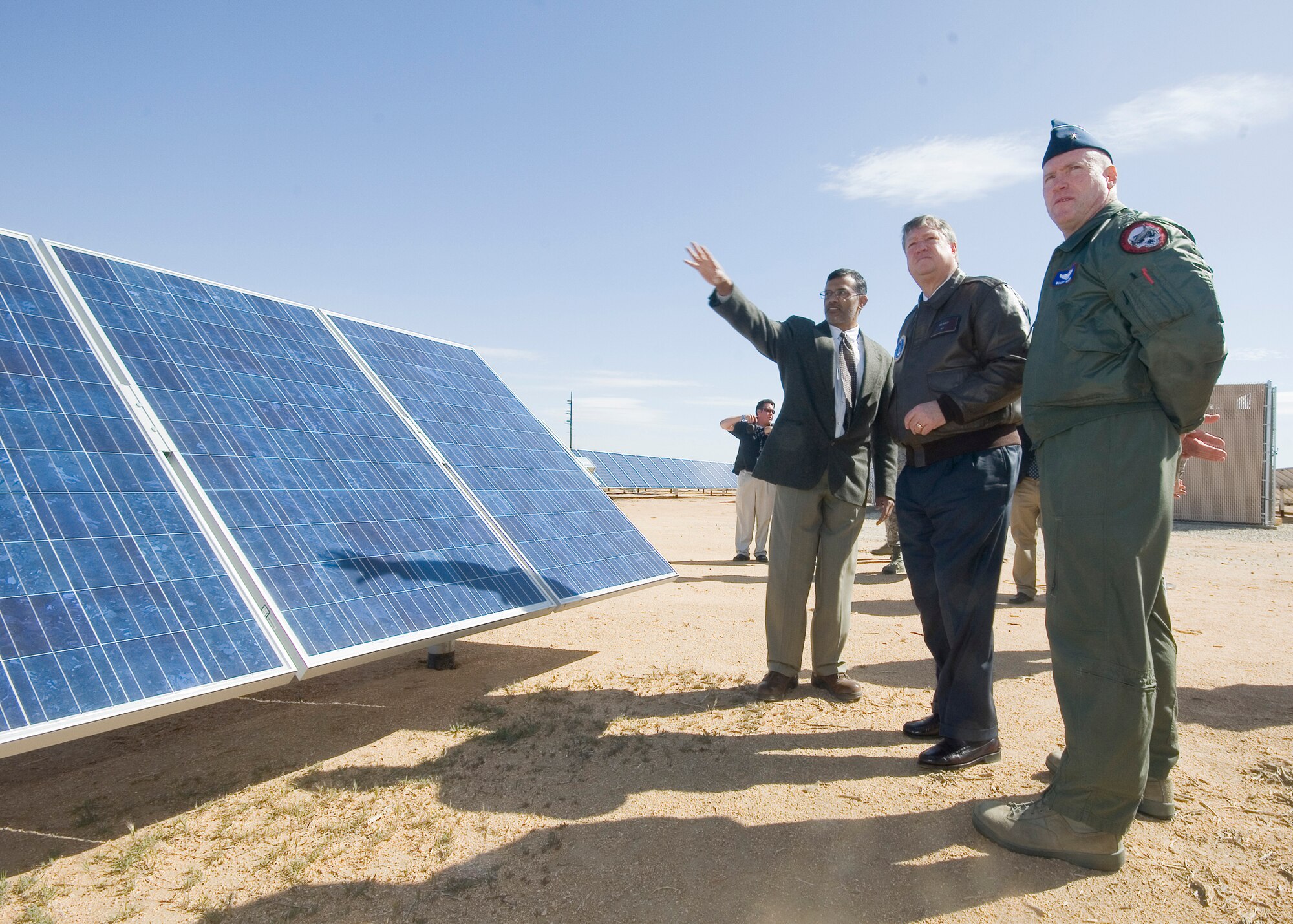 Yusuf Ahmed, 95th Civil Engineering electrical engineer (left), talks to Secretary of the Air Force Michael Donley about the three solar farms on Edwards Air Force Base March 27, as Brig. Gen. Robert C. Nolan II, Air Force Flight Test Center commander, looks on. The secretary cut a ceremonial ribbon at the Lancaster Blvd. solar farm to officially dedicate the three farms, which provide one megawatt each to the Edwards power grid. (U.S. Air Force photo/Rob Densmore)