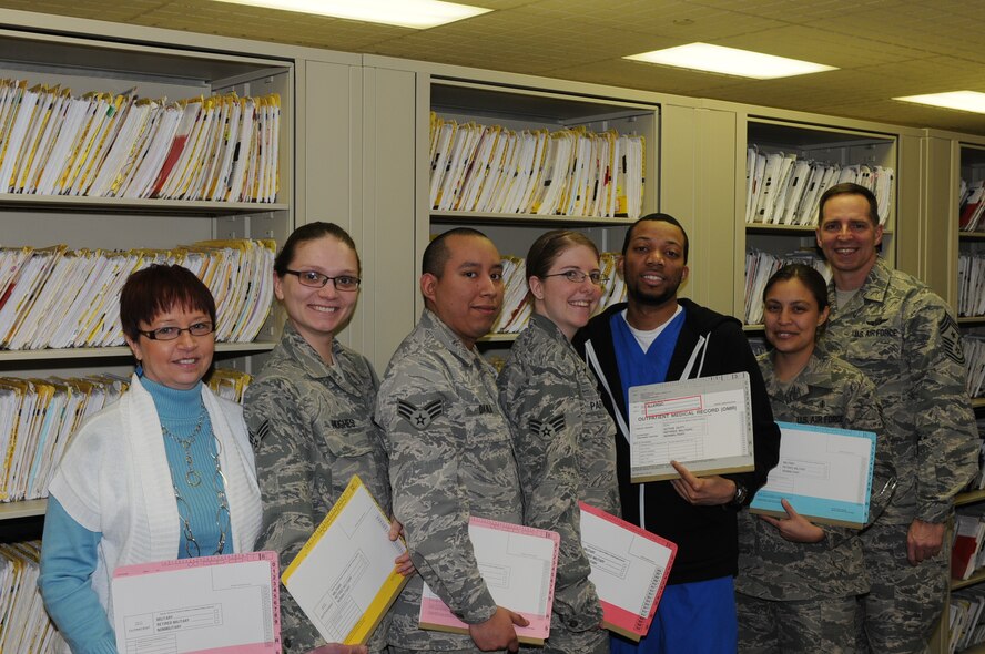 MINOT AIR FORCE BASE, N.D. -- From left to right: Kim Lemley, Senior Airman Elena Hughes, Senior Airman Jose Davila, Senior Airman Michelle Partridge, Demorris Harper, Staff Sgt. Lorry Arellano, Chief Master Sgt. Kevin Jurgella

The Outpatient Medical Records section at the 5th Medical Group is responsible for maintaining medical records for the more than 12,000 beneficiaries here at Minot Air Force Base. The 8-person team performs management functions during in- and out-processing, patient registration, filing and researching, as well as customer service on a daily basis. Records technicians also request, receive and file patient information received from off-base provider visits to ensure each member's medical records contain a complete history of care. Their ultimate focus is on providing the vital documents needed to maintain the health and well-being of Team Minot members, as they support and execute the dual wing nuclear mission. (Photo Submission/Tech. Sgt. Mark Frederici)
