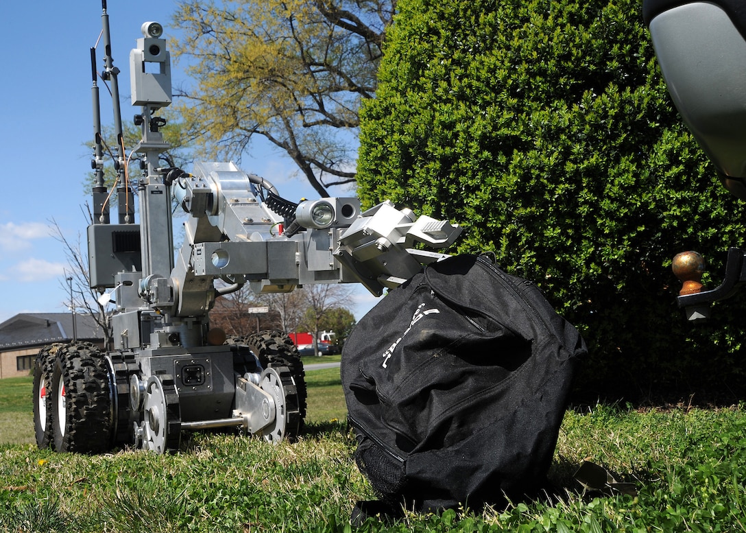 A remotely-controlled F-6A robot picks up a simulated Improvised Explosive Device during training conducted by the 11th Civil Engineer Squadron Explosive Ordnance Disposal technicians near the EOD headquarters here, March 29.  (U.S. Air Force Photo/Staff Sgt. Matt Coleman-Foster)