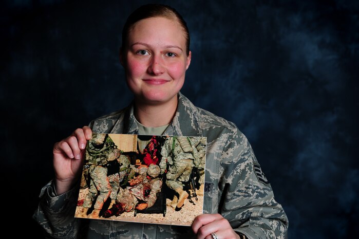 Staff Sgt. Ashley Hyatt shows her award winning photo, March 30 at Joint Base Charleston, S.C.  Hyatt took the photograph while at the National Training Center, Fort Irvine, Calif., in Sept. 2011.  The photograph is of a simulated wounded U.S. Army solider being transferred onto a litter during a training scenario in a simulated Afghan village. Hyatt's photo took first place after going up against 434 other entries in the combat documentation category during the Department of Defense's Annual Military Photographer of the Year competition.  Hyatt is from the 1st Combat Camera Squadron.  (U.S. Air Force photo/ Staff Sgt. Nicole Mickle)  