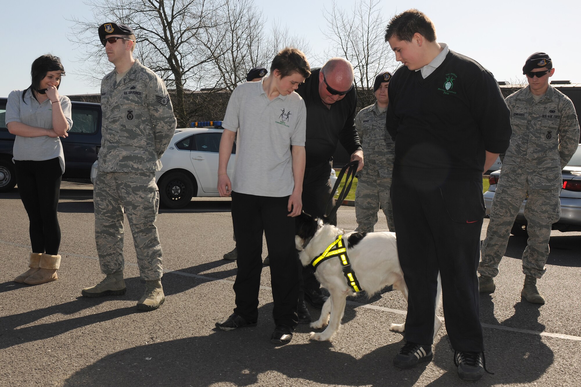 RAF ALCONBURY, United Kingdom - Bob Shaw, Ministry of Defence Police, shows students from The Manor a dog demonstration outside the 423rd Security Forces Squadron building March 27. The students were shown different activities the Defenders from the 423rd SFS do on a day-to-day basis. Airmen from the 423rd SFS participate in a weekly-mentorship program with the students. (U.S. Air Force photo by Senior Airman Joel Mease)