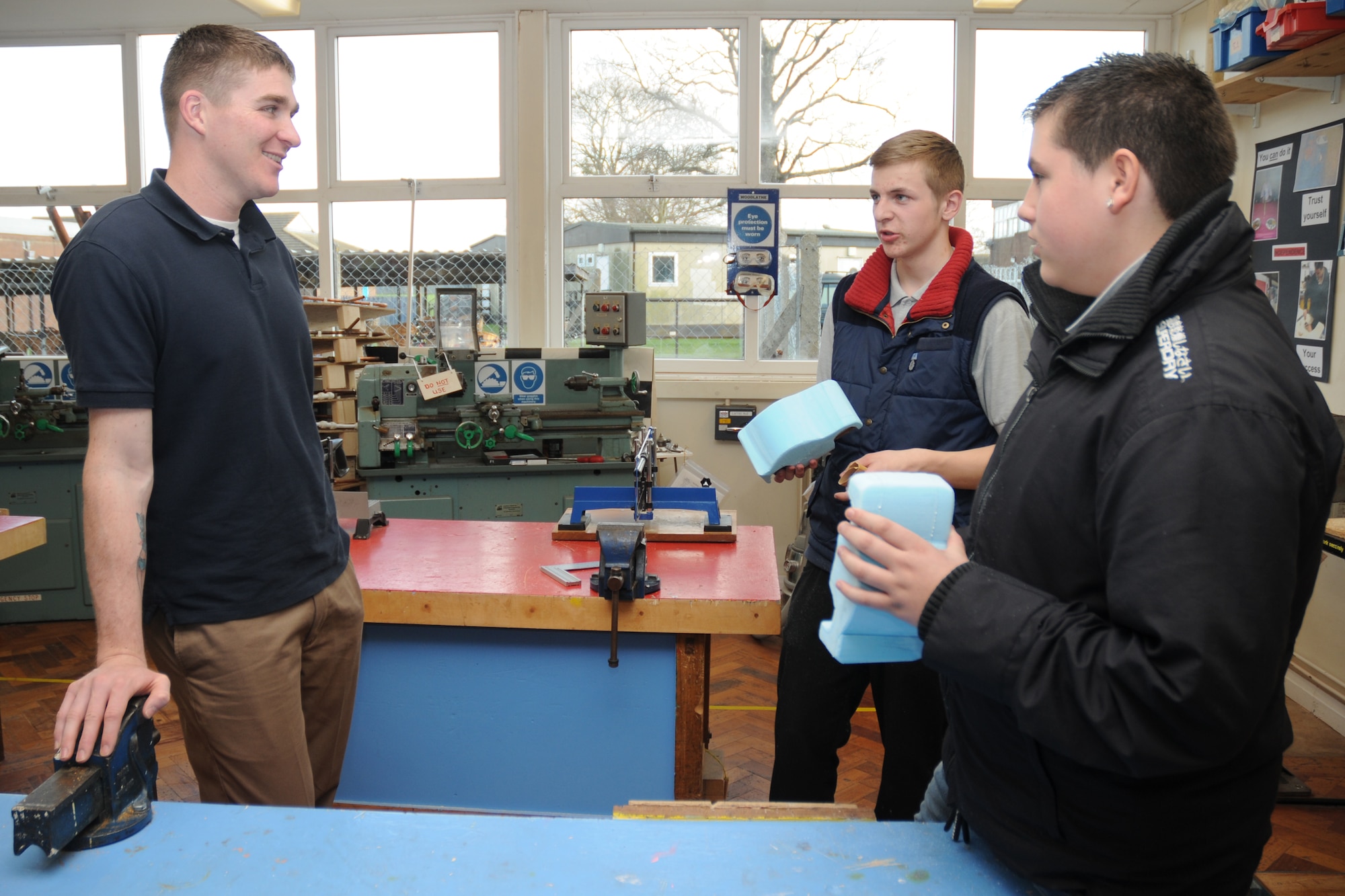 CAMBRIDGE, United Kingdom - Tech. Sgt. Devlin Stalion asks students at The Manor about their school project March 19. Airmen from the 423rd Security Forces Squadron participate in a weekly-mentorship program with the students. (U.S. Air Force photo by Senior Airman Joel Mease)