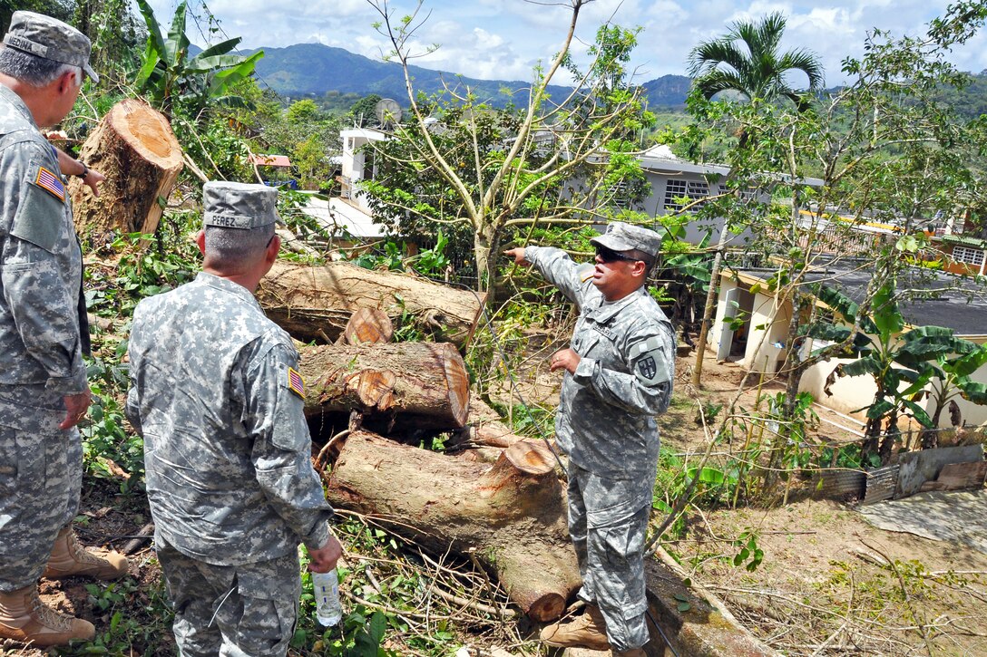 U.S. Army Brig. Gen. Victor Perez, center, director of the joint staff for the Puerto Rico Army National Guard, listens as U.S. Army Lt. Col. Samuel Agosto briefs him while surveying mudslide damage in Utuado, Puerto Rico, March 31, 2012. Agosto is the commander of the 130th Engineer Battalion.