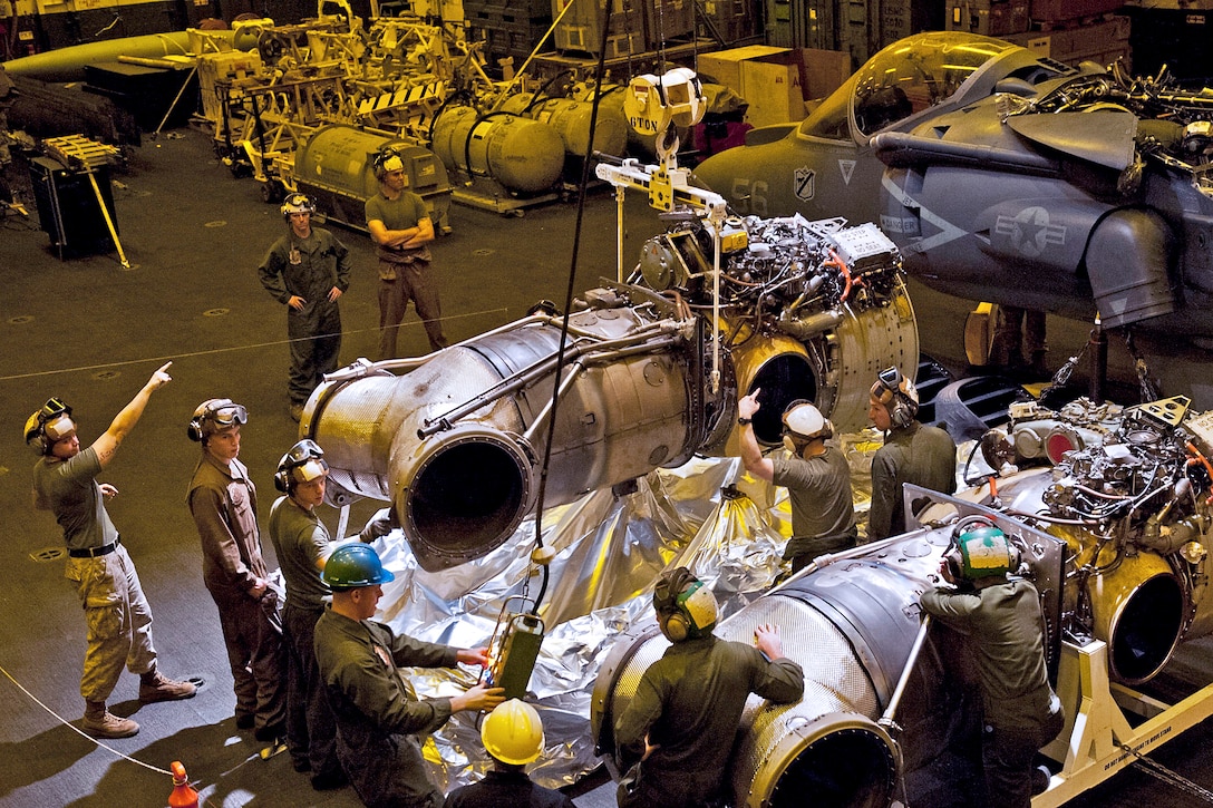 a U.S. Marine maintenance crew guides the engine of an AV-8B Harrier after removing it from the aircraft in the hangar bay of the amphibious assault ship USS Makin Island under way in the Arabian Sea, March 30, 2012. The Makin Island and embarked Marines are supporting maritime security operations and theater security cooperation efforts in the U.S. 5th Fleet area of responsibility. The Marines are assigned to the 11th Marine Expeditionary Unit.