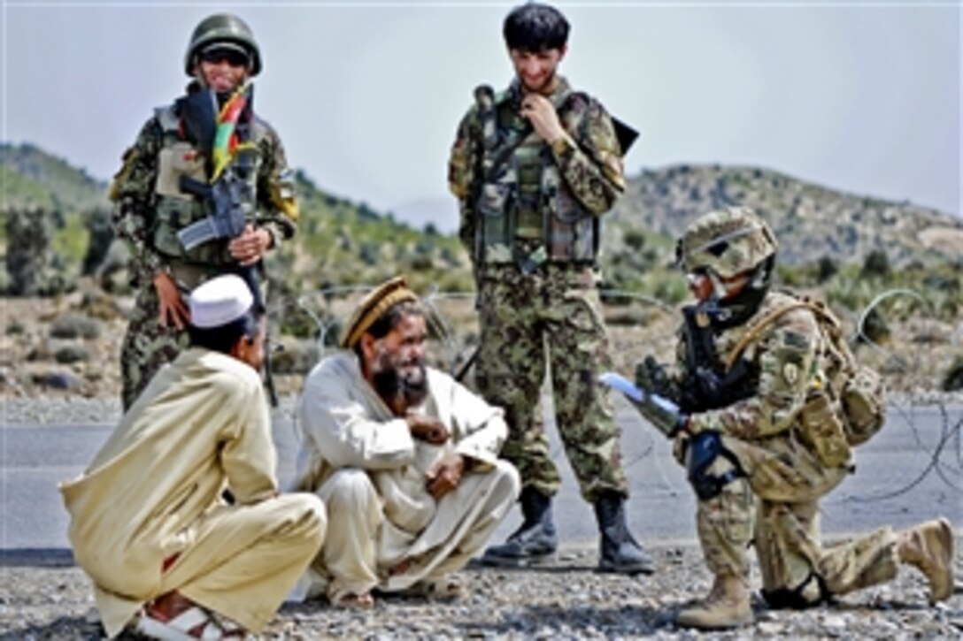 U.S. Army Spc. Shawnte Rollins, right, and Afghan soldiers collect information from motorists passing through a temporary control point at Chenigai Pass in the Bak district in Afghanistan's Khowst province, March 30, 2012. Rollins is assigned to Company D, 1st Battalion, 501st Infantry Regiment.