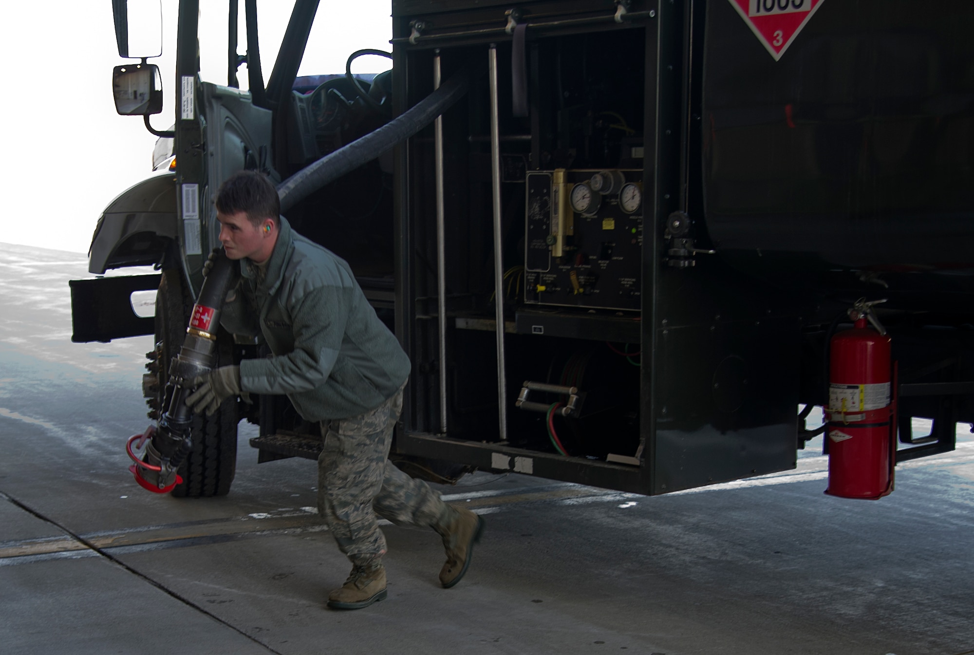 Airman 1st Class Jeremy Miller, 673d Logistics Readiness Squadron fuels apprentice, unrolls the fueling hose of the R-11 fuel truck on Joint Base Elmendorf-Richardson April 3, 2012. The fueling is a transaction between Miller and the crew chief who actually signs for the fuel. (U.S. Air Force photo/Staff Sgt. Zachary Wolf)