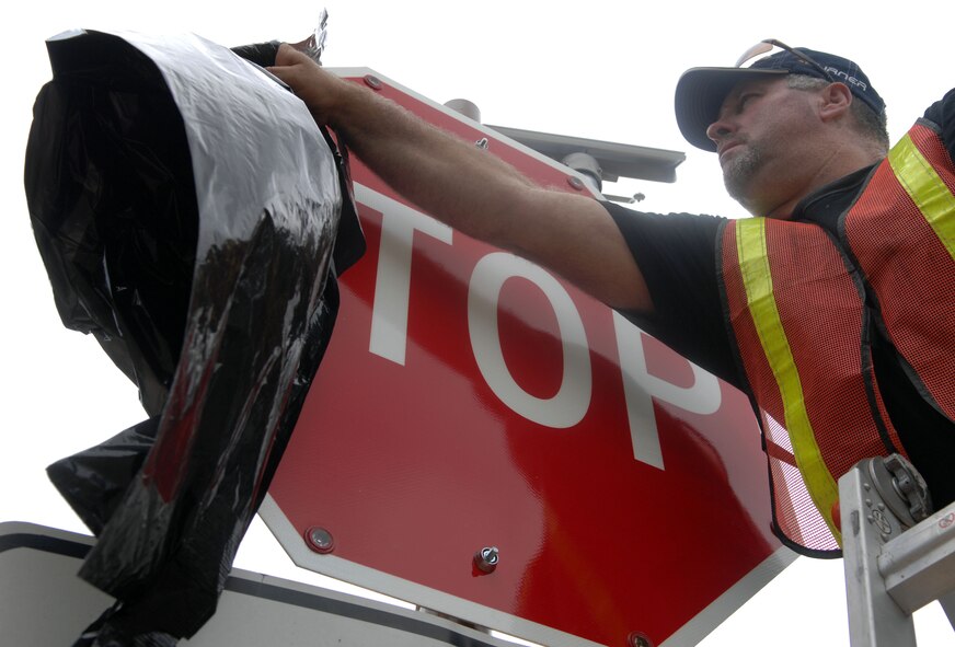 Jerry Jacobson, 2nd Civil Engineer Squadron, removes a plastic cover from a stop sign on Barksdale Air Force Base, La., April 3. Jacobson revealed the new stop sign at the intersection of Davis Avenue West and Barksdale Boulevard West. (U.S. Air Force photo/Airman 1st Class Joseph A. Pagán Jr.)(RELEASED)