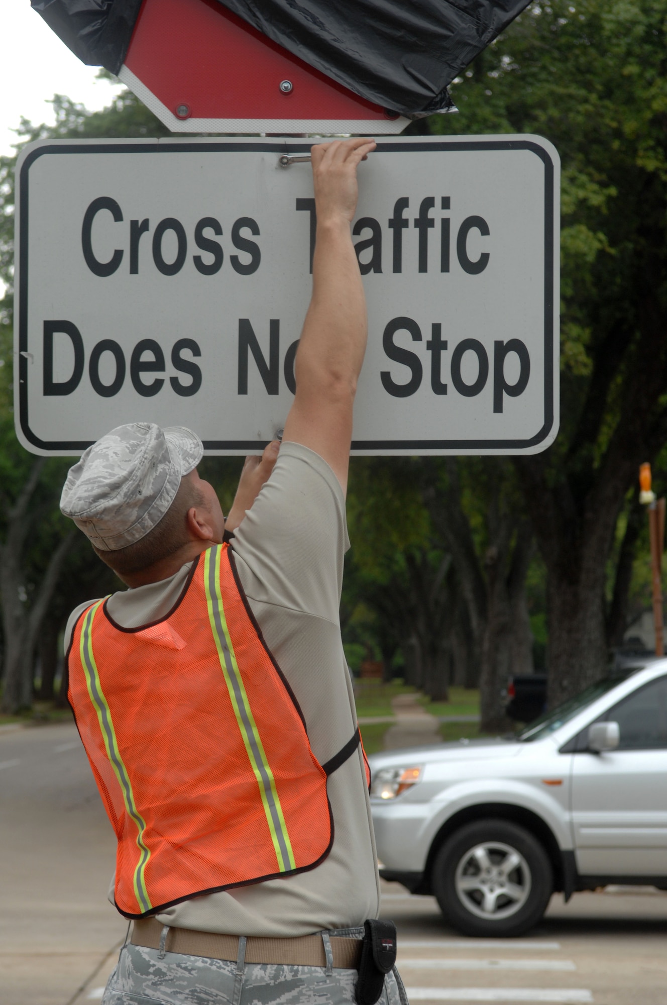 Tech. Sgt. Floyd Butkiewicz, 2nd Civil Engineer Squadron, tightens a bolt on a traffic sign on Barksdale Air Force Base, La., April 3. Butkiewicz installed the sign to a newly placed stop sign on the intersection of Davis Avenue West and Barksdale Boulevard West. Previously, traffic coming from Davis Avenue West had the right-of-way. (U.S. Air Force photo/Airman 1st Class Joseph A. Pagán Jr.)(RELEASED)