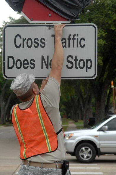 Tech. Sgt. Floyd Butkiewicz, 2nd Civil Engineer Squadron, tightens a bolt on a traffic sign on Barksdale Air Force Base, La., April 3. Butkiewicz installed the sign to a newly placed stop sign on the intersection of Davis Avenue West and Barksdale Boulevard West. Previously, traffic coming from Davis Avenue West had the right-of-way. (U.S. Air Force photo/Airman 1st Class Joseph A. Pagán Jr.)(RELEASED)