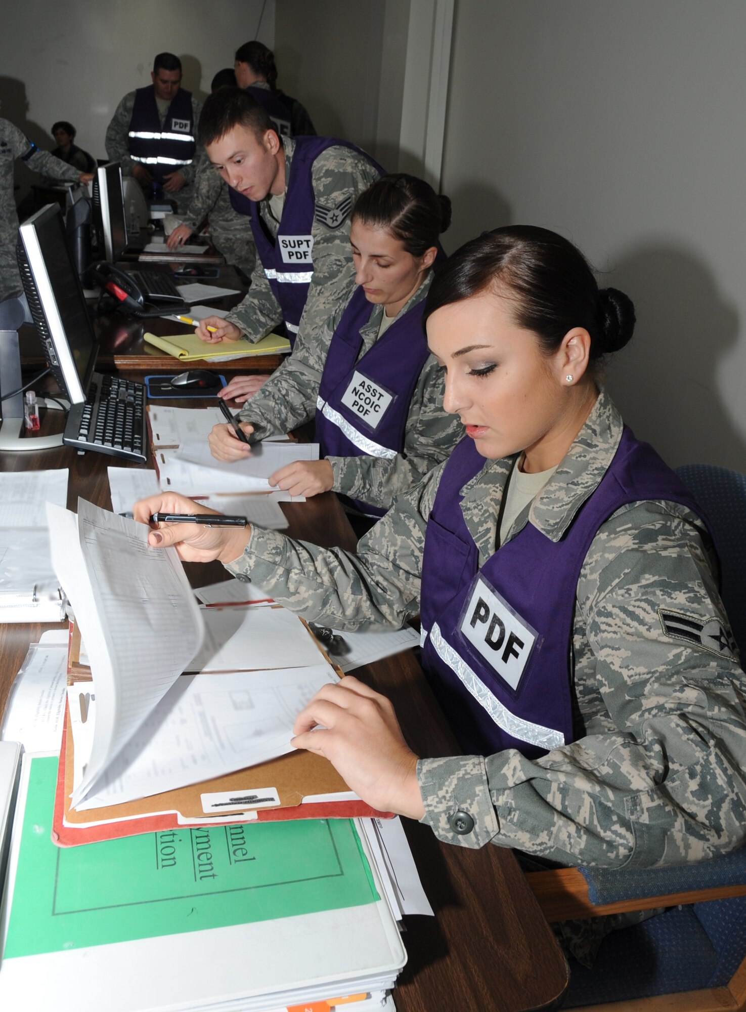 Staff Sgt. David Cannon, Senior Airman Sadie Barcroft, and Airman First Class Carly Cervantes, 81st Force Support Squadron, verify deployment eligibility during a deployment exercise March 29, 2012, outside the 81st Logistics Readiness Squadron warehouse at Keesler Air Force Base, Miss.  (U.S. Air Force photo by Kemberly Groue)
