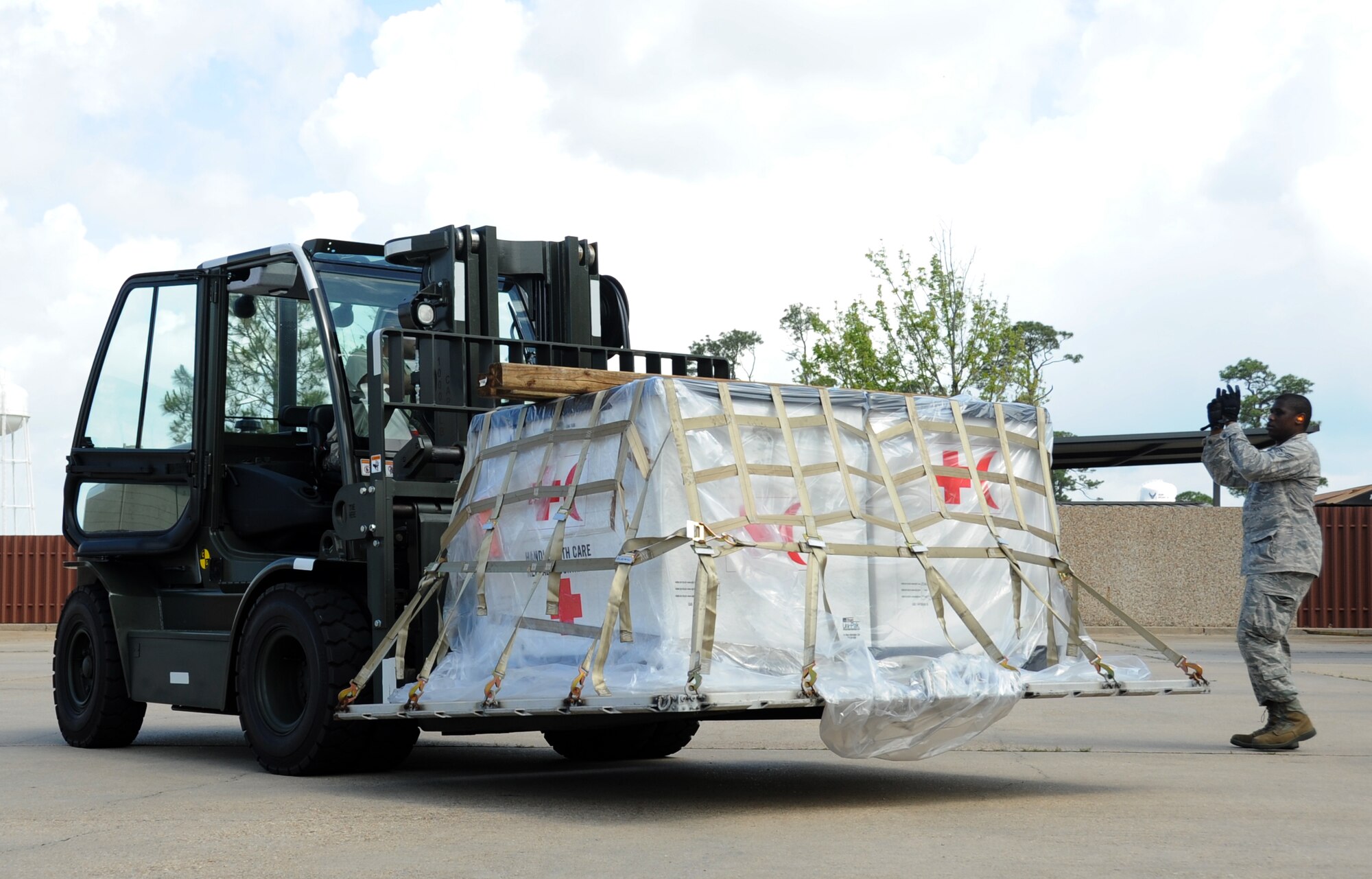 Staff Sgt. Jason Sweigart, 81st Logistics Readiness Squadron, operates a forklift carrying Medical Group cargo for deploying as Senior Airman David Thatcher, 81st LRS, guides him safely to the location for unloading the cargo during a deployment exercise March 29, 2012, outside the 81st Logistics Readiness Squadron warehouse at Keesler Air Force Base, Miss.  (U.S. Air Force photo by Kemberly Groue)