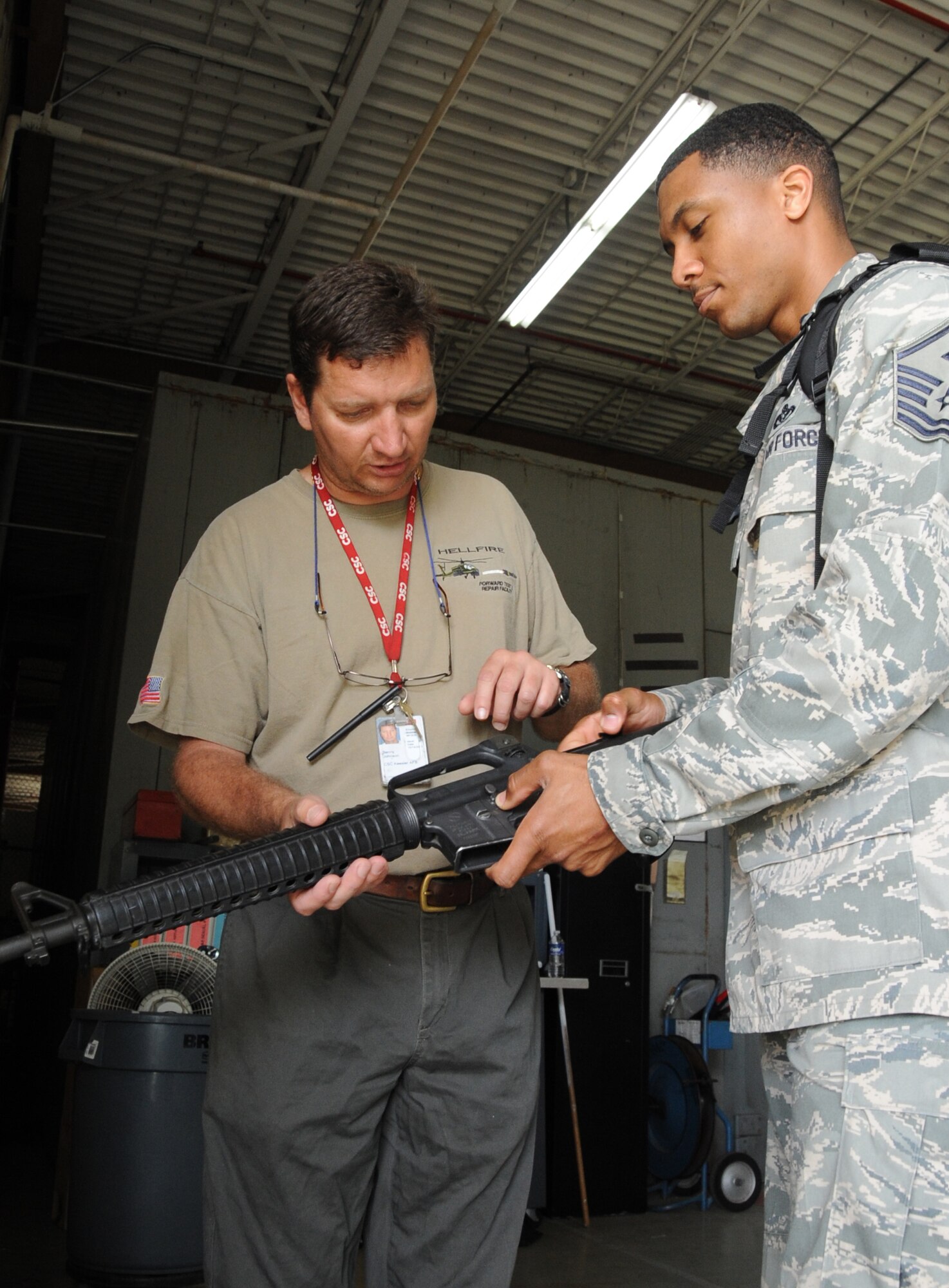 Benny Johnson, CSC, guides Master Sgt. Kendal Dismute, 81st Diagnostic and Therapeutics Squadron, through the procedure of unloading an M-16A2 rifle during the deployment exercise March 29, 2012, inside the 81st Logistics Readiness Squadron warehouse at Keesler Air Force Base, Miss.  (U.S. Air Force photo by Kemberly Groue)