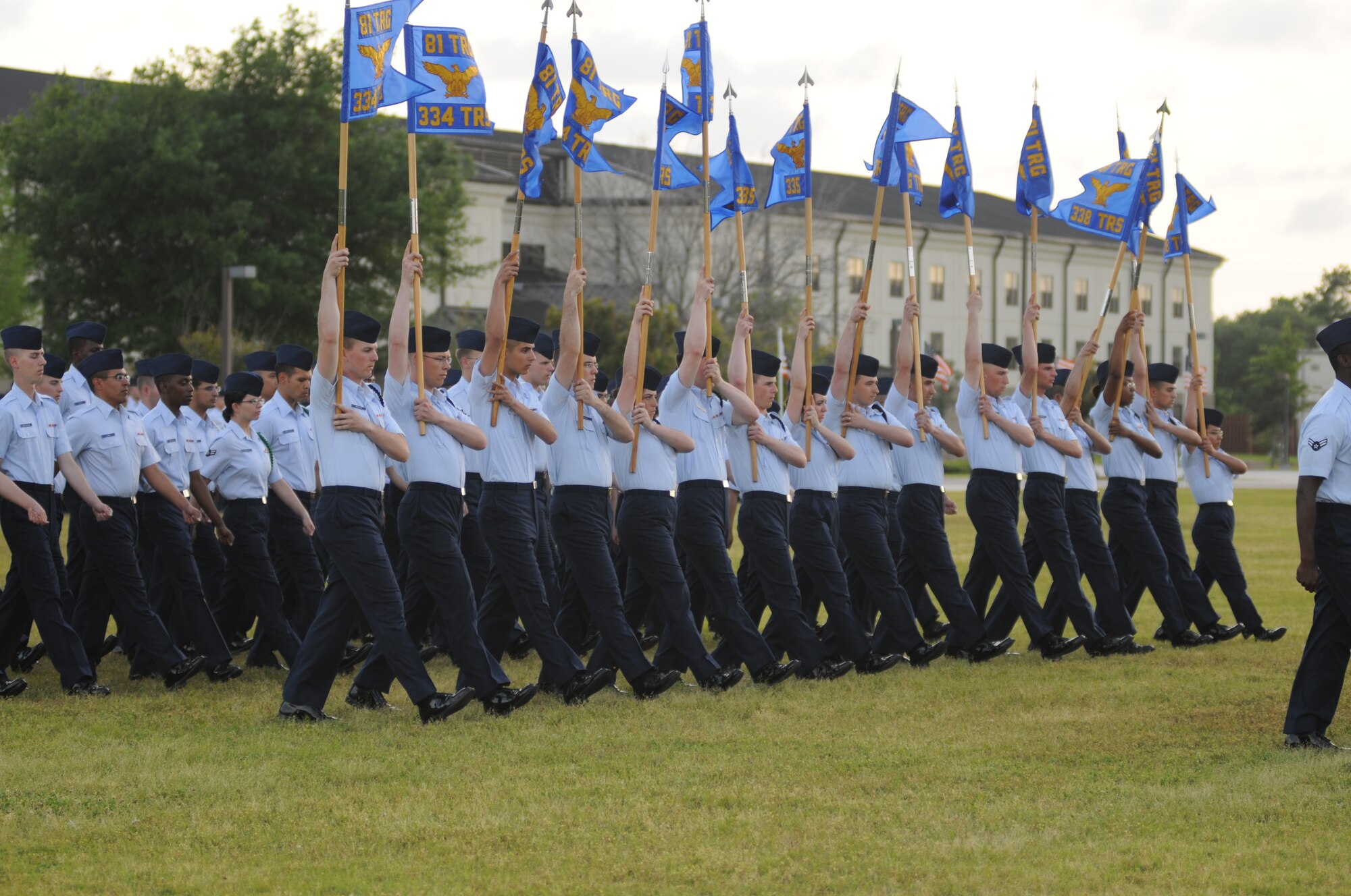 The guidon bearers raise their guidons to salute in the Officers Center during the student parade March 29, 2012, in the triangle area at Keesler Air Force Base, Miss.  (U.S. Air Force photo by Kemberly Groue)