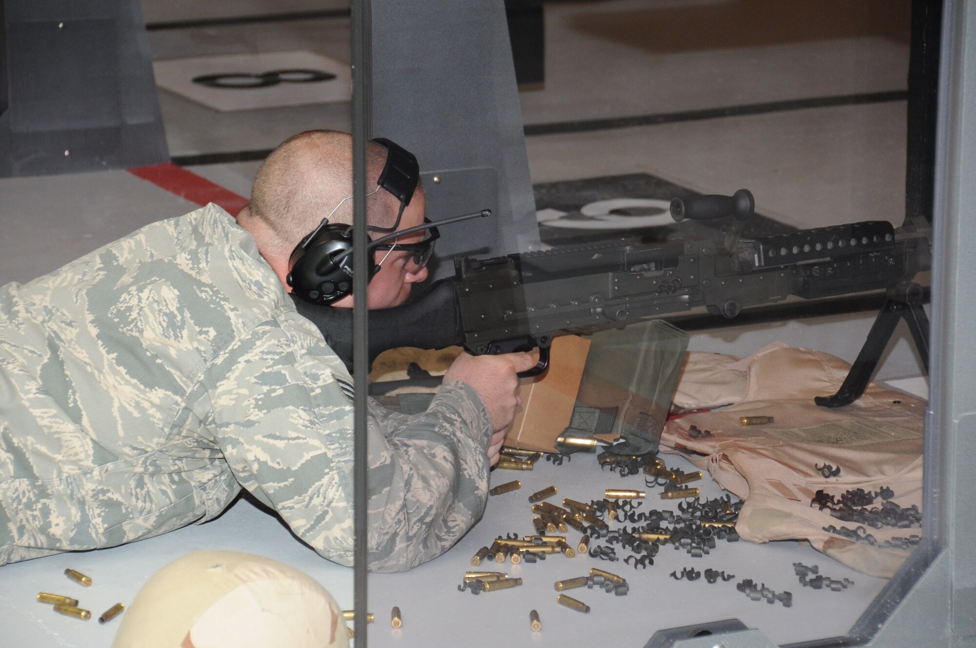 Senior Airman Jesse Peterson, 81st Security Forces Squadron combat arms, opens fire during a 10-meter machine gun qualification course test during an indoor firing range safety test March 28, 2012, at Keesler Air Force Base, Miss.  The safety tests were conducted to ensure that rounds would not ricochet back toward members firing their weapons.  (U.S. Air Force photo by Kemberly Groue)