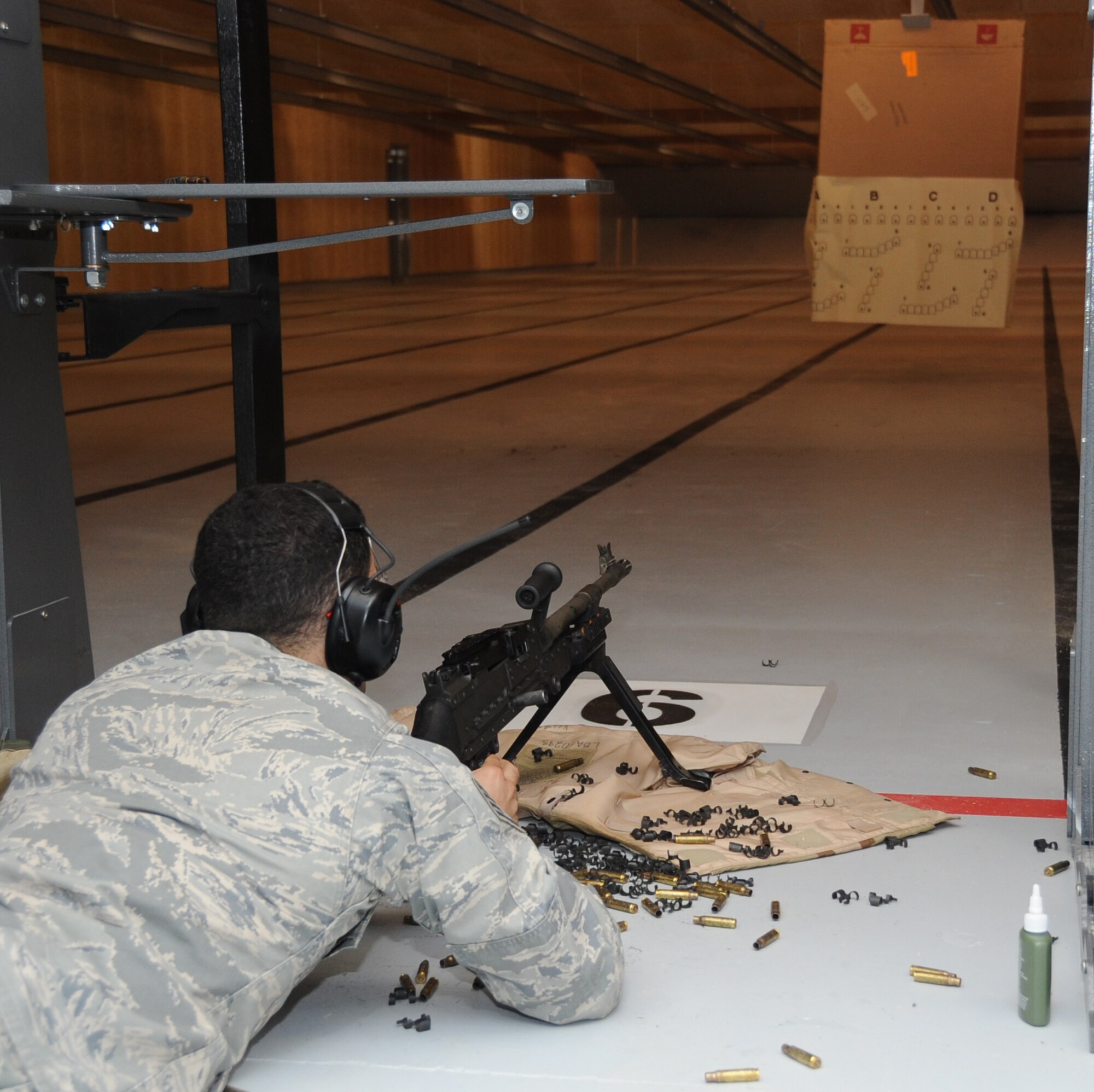 Staff Sgt. Christopher Hernandez, 81st Security Forces Squadron combat arms, opens fire during a 10-meter machine gun qualification course test during an indoor firing range safety test March 28, 2012, at Keesler Air Force Base, Miss.  The safety tests were conducted to ensure that rounds would not ricochet back toward members firing their weapons.  (U.S. Air Force photo by Kemberly Groue)