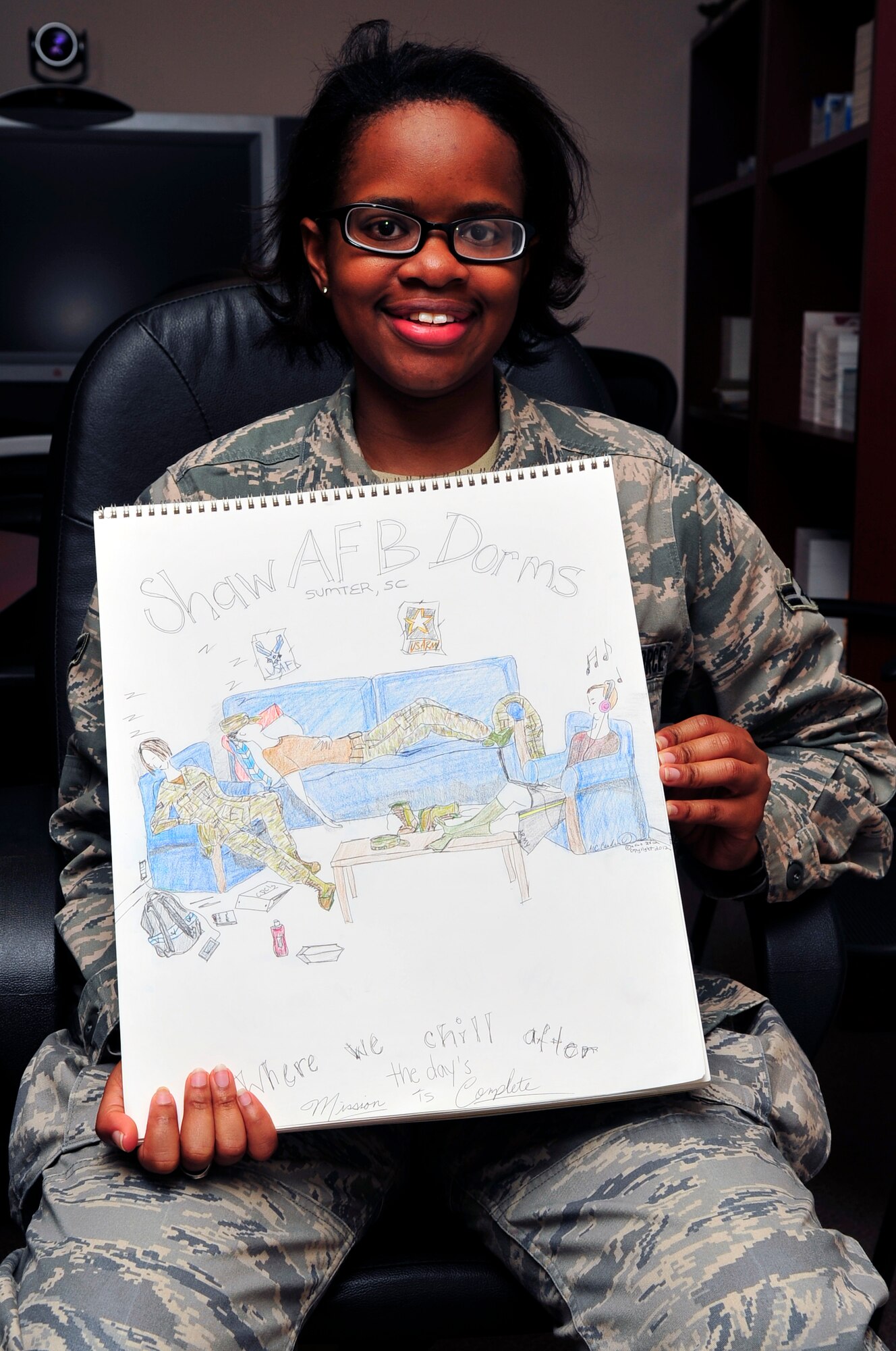 Airman 1st Class Candice Moore, 20th Medical Operations Squadron mental health technician, shows off the original piece of artwork she created for the Shaw dorm logo, Shaw Air Force Base, S.C., March 30, 2012. She was asked by 20th MDG leadership to design this coin after winning the dorm logo competition. (U.S. Air Force photo by Senior Airman Daniel Phelps)