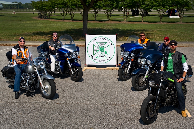 The Green Knights Military Motorcycle Club pose for a group photo with their banner at Joint Base Charleston - Air Base April 2. The Green Knights are a non-profit organization for military and Department of Defense motorcyclists and has more than 100 chapters all over the world. (U.S. Air Force photo by Airman 1st Class George Goslin)