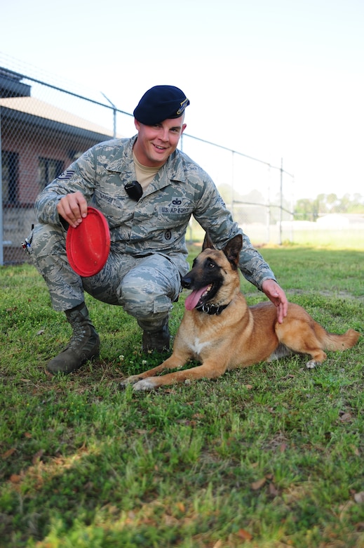 Staff Sgt. Timothy Garrett pets Akim, a Belgian Malanois, at Joint Base Charleston - Air Base March 29. The 628th Security Forces Squadron's K-9 unit animals undergo six to eight months of training for drug and explosive detection. Garrett is a military working dog handler and Akim is a military working dog, both are with the 628th SFS. (U.S. Air Force photo/ Airman 1st Class Chacarra Walker)