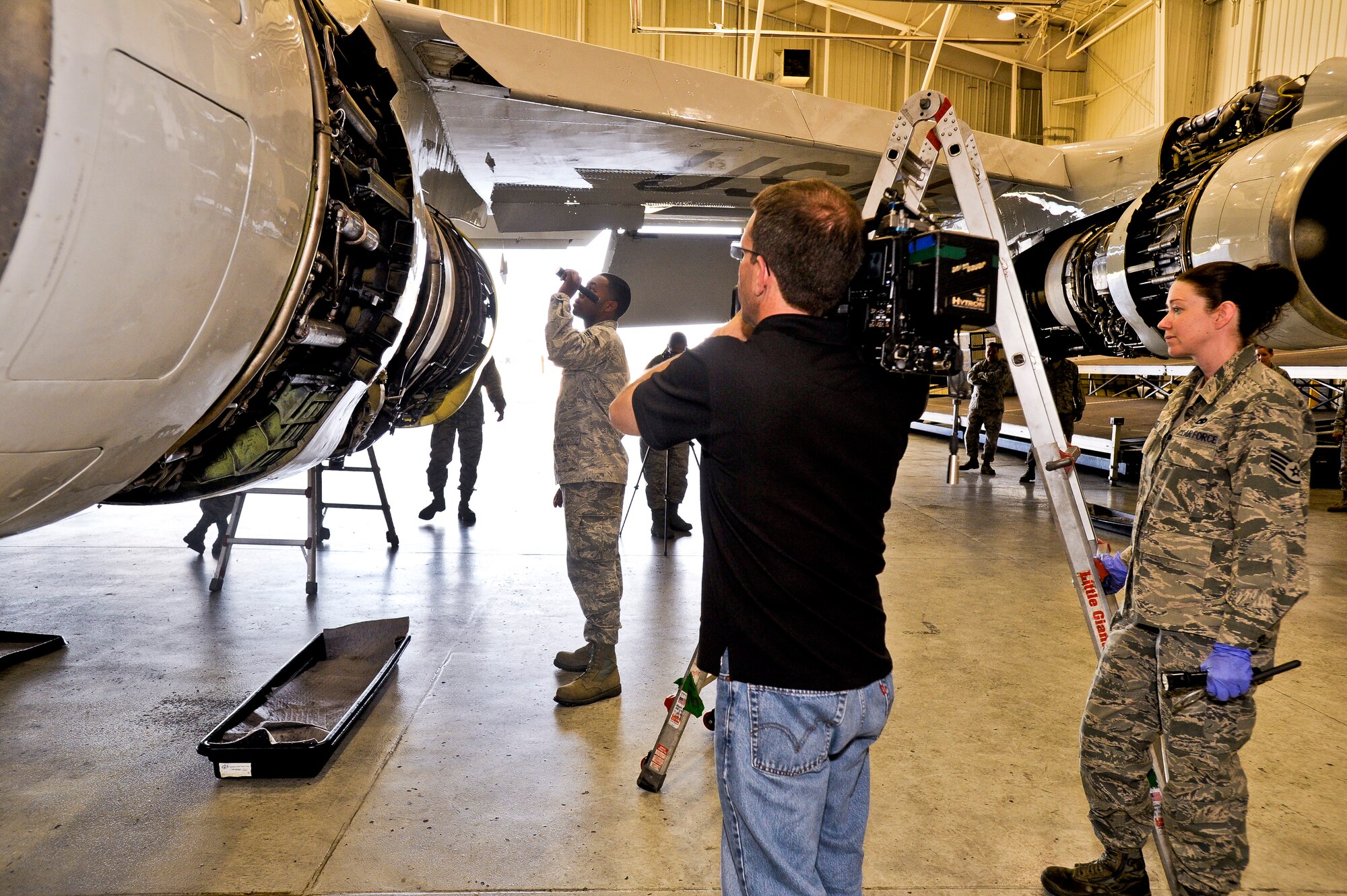Ferre Dollar, a videographer with CNN, captures video footage of maintenance being performed on the engine of an E-8C Joint STARS at Robins Air Force Base, Ga., March 27, 2012.  JSTARS was one of several units the news organization visited during a tour of Robins Air Force Base.  (U. S. Air Force photo by Master Sgt. Roger Parsons)
