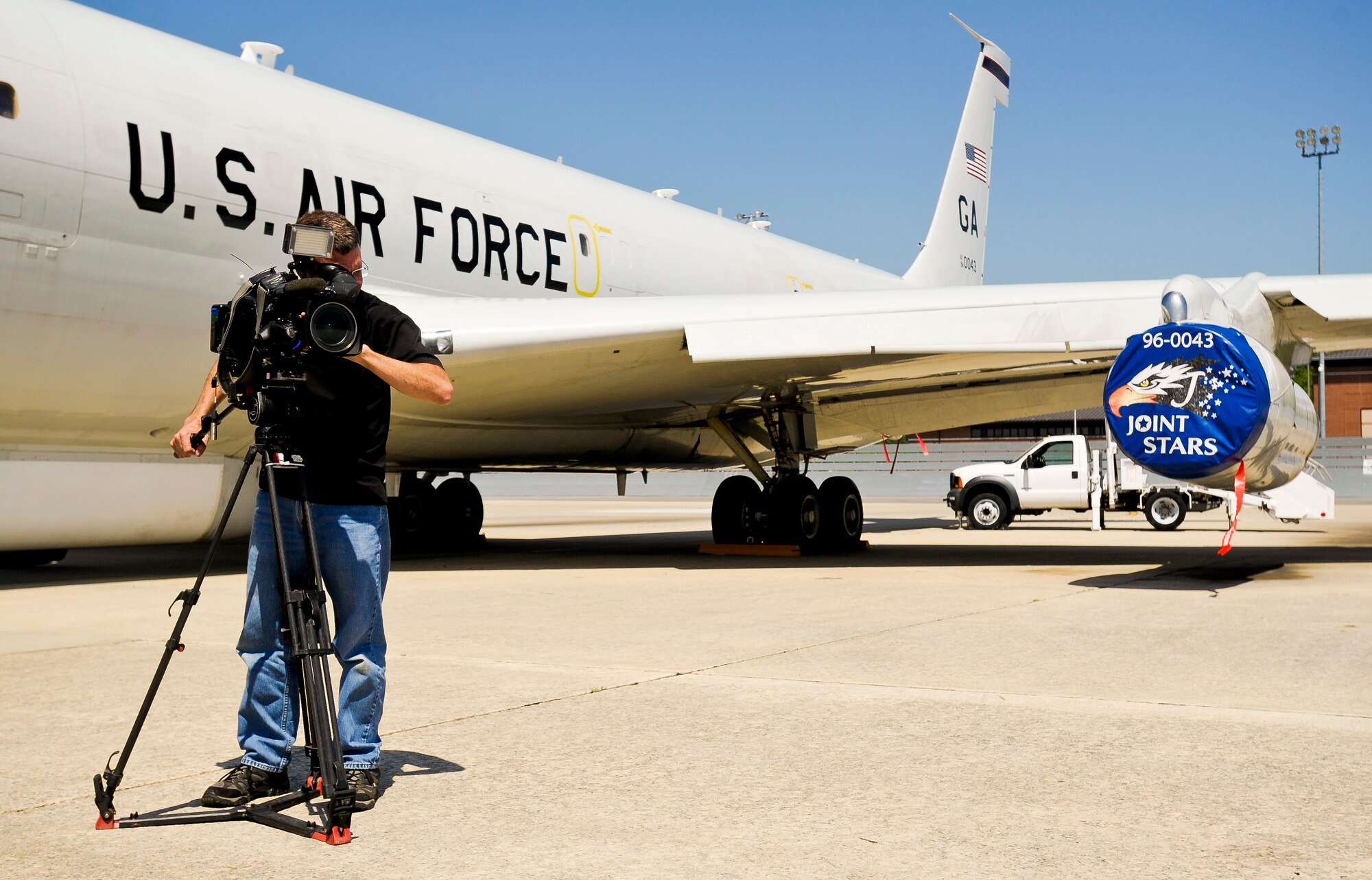 Ferre Dollar, a videographer with CNN, shoots video footage in front of an E-8C Joint STARS at Robins Air Force Base, Ga., March 27, 2012.  JSTARS was one of several units the news organization visited during a tour of Robins Air Force Base.  Dollar was capturing footage of another JSTARS taxiing in from a flight.  (U. S. Air Force photo by Master Sgt. Roger Parsons)
