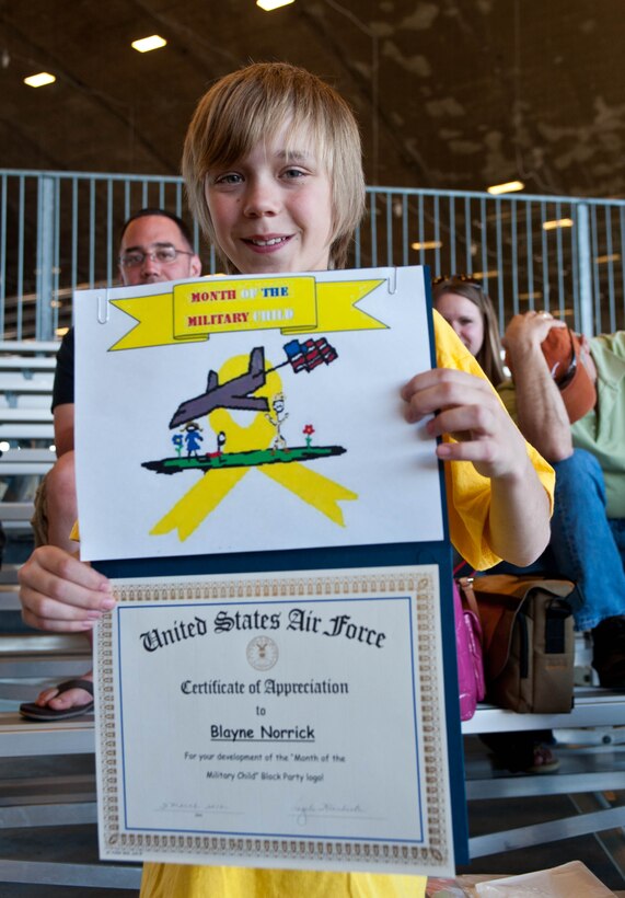 Blayne Norrick, son to Tech. Sgt. Curtis Norrick, 28th Aircraft Maintenance Squadron crew chief, receives a certificate of appreciation for developing the logo for the Month of the Military Child block party at Ellsworth Air Force Base, S.D., March 31, 2012. The military community has approximately1.8 million children and young adults under 18. (U.S. Air Force photo by Airman 1st Class Zachary Hada/Released)