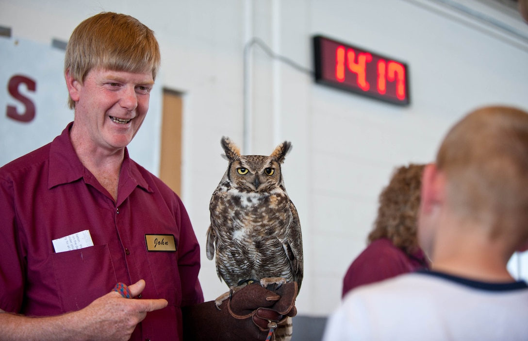 John Halverson, Black Hills Raptor Center bird handler, educates and introduces children to Icarus the owl at the military child block party at Ellsworth Air Force Base, S.D., March 31, 2012. The Month of the Military Child, done every April, celebrates the contributions and sacrifices made by military children. (U.S. Air Force photo by Airman 1st Class Zachary Hada/Released)