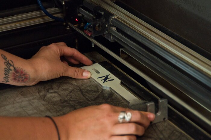 Myrna Loughery, 99th Force Support Squadron Arts and Crafts Center laser engraver, places a piece into the laser engraver for etching March 30, 2012 at Nellis Air Force Base’s Arts and Crafts Center. The Arts and Crafts Center can customize many items including awards and retirement or going-away gifts. (U.S. Air Force photo by Senior Airman Jack Sanders)
