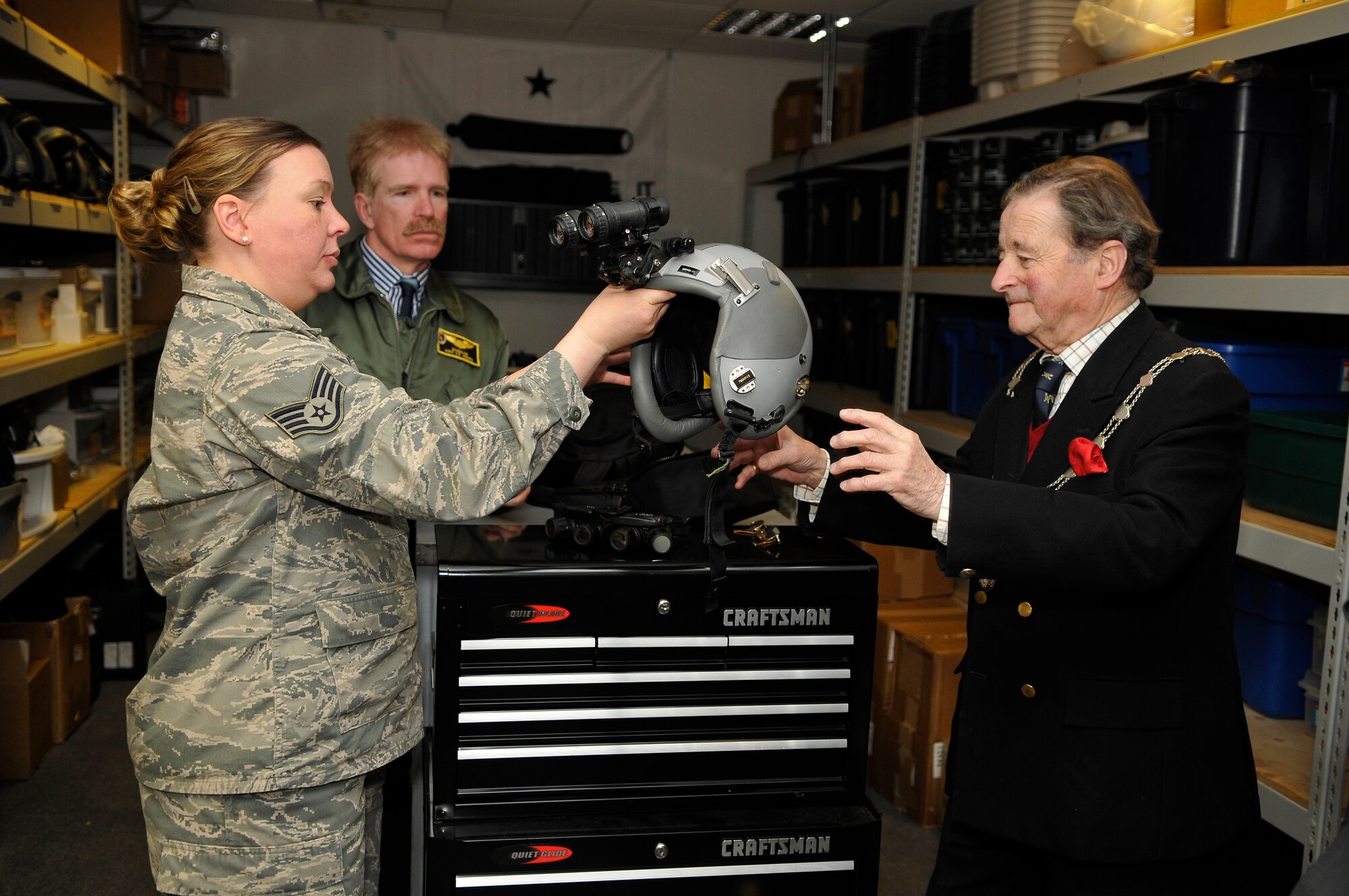 ROYAL AIR FORCE LAKENHEATH, England -- Staff Sgt. Jessica Jackson, 493rd FS aircrew flight equipment craftsman, gives The Worshipful The Mayor of St. Edmundsbury, Councillor Christopher Spicer, an HGU-55/P Flyer?s Helmet with night vision goggles to try on during his tour through the 493rd FS April 2, 2012.  Councillor Spicer toured the 493rd FS facilities to learn more about the history of the unit, to meet with the Airmen and to try on equipment from the life support section.  (U.S. Air Force photo by Staff Sgt. Connor Estes)