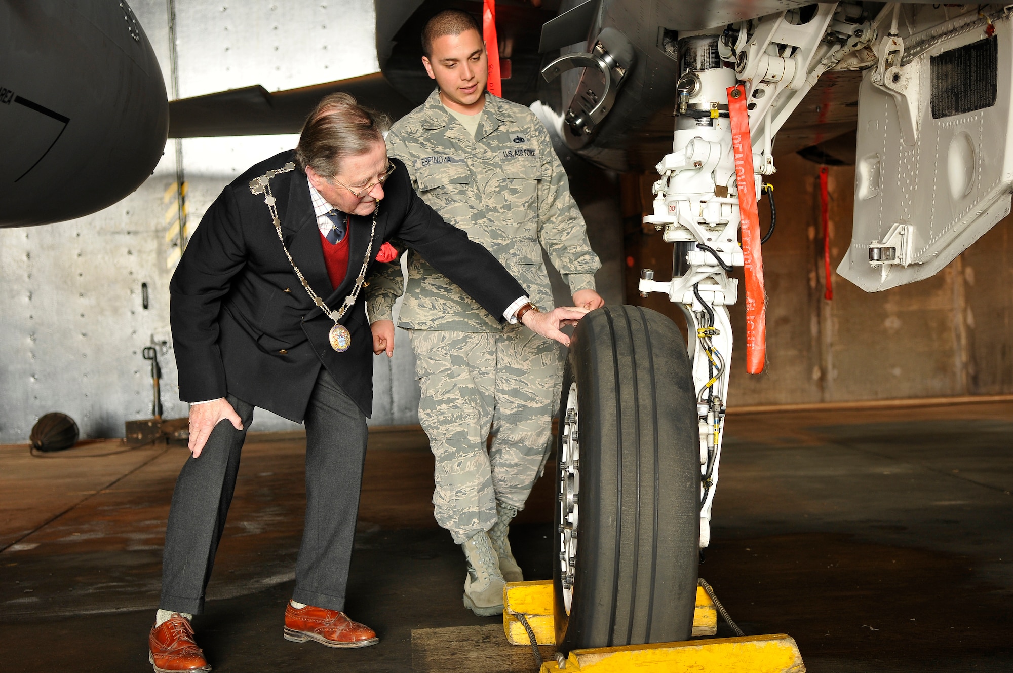 ROYAL AIR FORCE LAKENHEATH, England -- The Worshipful The Mayor of St. Edmundsbury, Councillor Christopher Spicer, looks over an F-15C Eagle aircraft tire with Staff Sgt. Marlon Espinoza, 748th Aircraft Maintenance Squadron dedicated crew chief, on the RAF Lakenheath flightline during his tour of the 493rd Fighter Squadron April 2, 2012.  Councillor Spicer toured the 493rd FS facilities to learn more about the history of the unit, to meet with the Airmen and to try on equipment from the life support section.  (U.S. Air Force photo by Staff Sgt. Connor Estes)