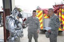Staff Sgt. Justin Hrusovsky (center) and Airman Corey Lindner (left), 902nd Civil Engineer Squadron firefighters, demonstrate fire protection equipment to Chief Master Sgt. Jose LugoSantiago, 502nd Air Base Wing command chief, Tuesday at Joint Base San Antonio-Randolph. LugoSantiago visited several 902nd Mission Support Group organizations during his immersion tour. Lugo-Santiago has been at the 502nd ABW for about two weeks. He was previously assigned at Joint Base Charleston. (U.S. Air Force photo/by Joel Martinez)