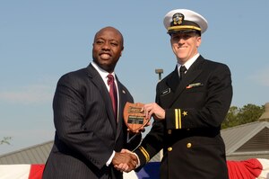 Lt. j.g. Henry Donaghy receives the Vice-Adm. Behrens award from U.S. Rep. Tim Scott during the Naval Nuclear Power Training Command graduation ceremony for class 1107 at Joint Base Charleston – Weapons Station, March 30. The Behrens award recognizes the graduating officer with the highest grade-point average. Scott is the South Carolina first district congressman.  (U.S. Air Force photo/Tech Sgt. Chrissy Best)