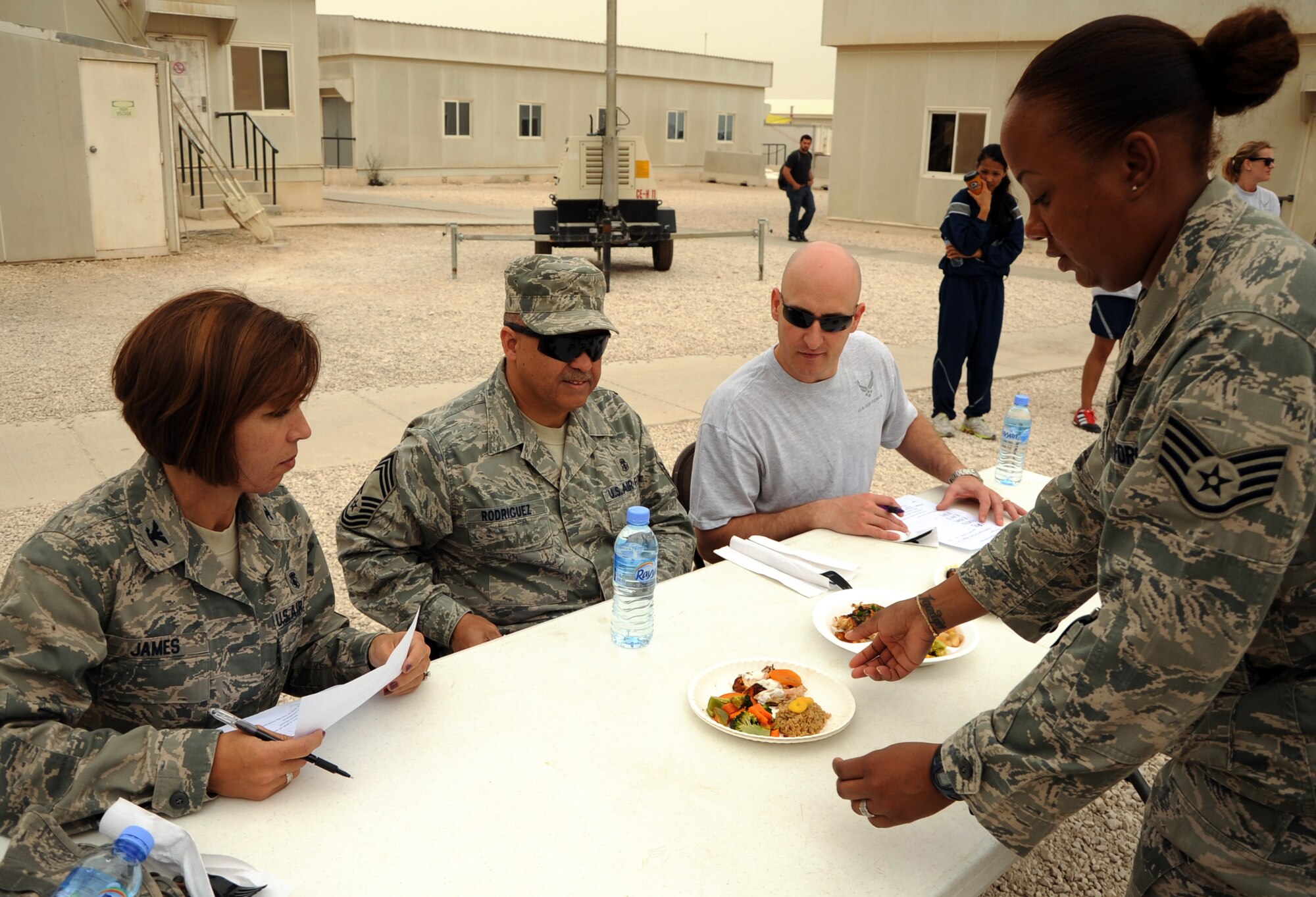 SOUTHWEST ASIA -- Staff Sgt. Renee Herbert, a 8th Expeditionary Air Mobility Squadron member, presents her teams dish before the panel of judges during the installation’s first Warrior Chef Challenge April 1, here at the Memorial Plaza.  Each team was given a set of ingredients and only 45 minutes to produce a meal for three judges. The installation’s Rising 6 organization sponsored the competition as a teambuilding and moral event based on the annual Air Force-wide cooking competition held in Washington, D.C. (U.S. Air Force photo/Senior Airman Michael Charles)