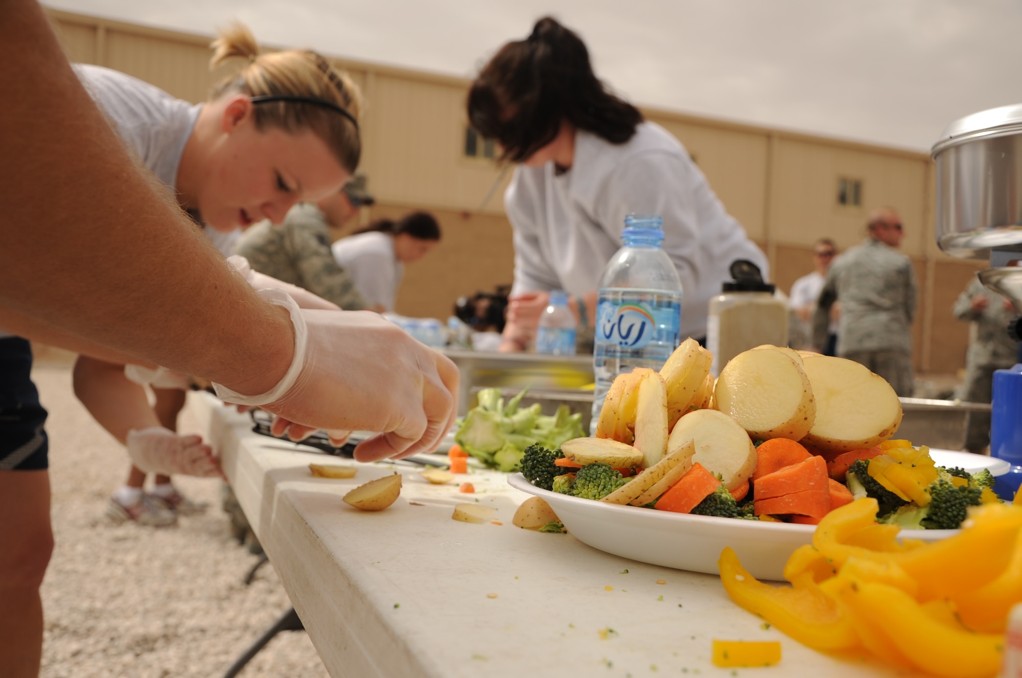 SOUTHWEST ASIA -- Members of the 379th Expeditionary Maintenance Squadron team slice vegetables while competing in the installation’s first Warrior Chef Challenge April 1, here at the Memorial Plaza. The installation’s Rising 6 organization sponsored the competition as a teambuilding and moral event based on the annual Air Force-wide cooking competition held in Washington, D.C.  (U.S. Air Force photo/Senior Airman Michael Charles)