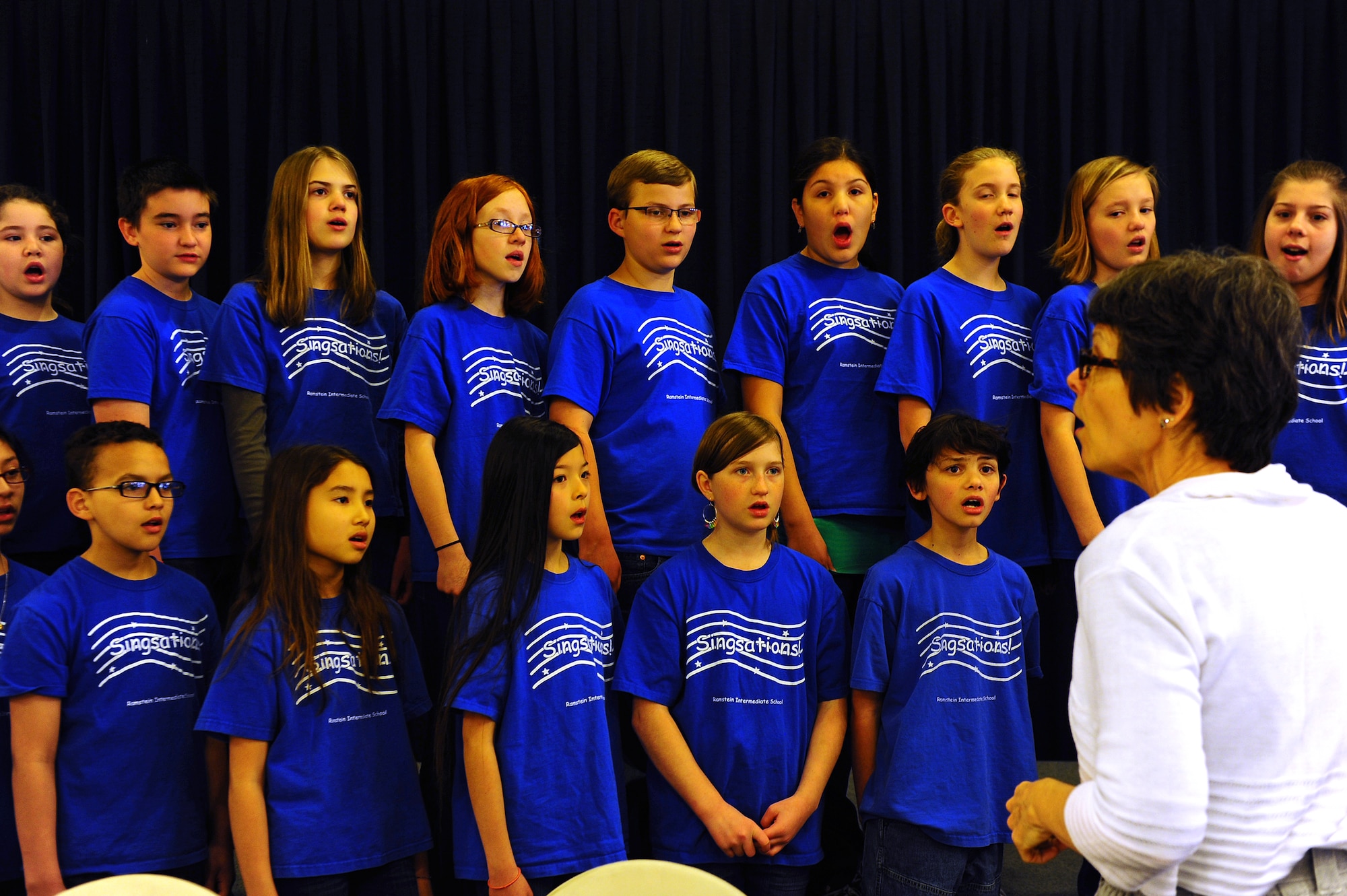 Ms. Brenda Barbour, Ramstein Intermediate School music teacher, directs the Singsations in a performance during the first Joint Community Town Hall on Ramstein Air Base, Germany, April 3, 2012. The event provided Kaiserslautern Military Community members the opportunity to address issues of mutual
concern. (U.S. Air Force photo/Airman Brea Miller)
